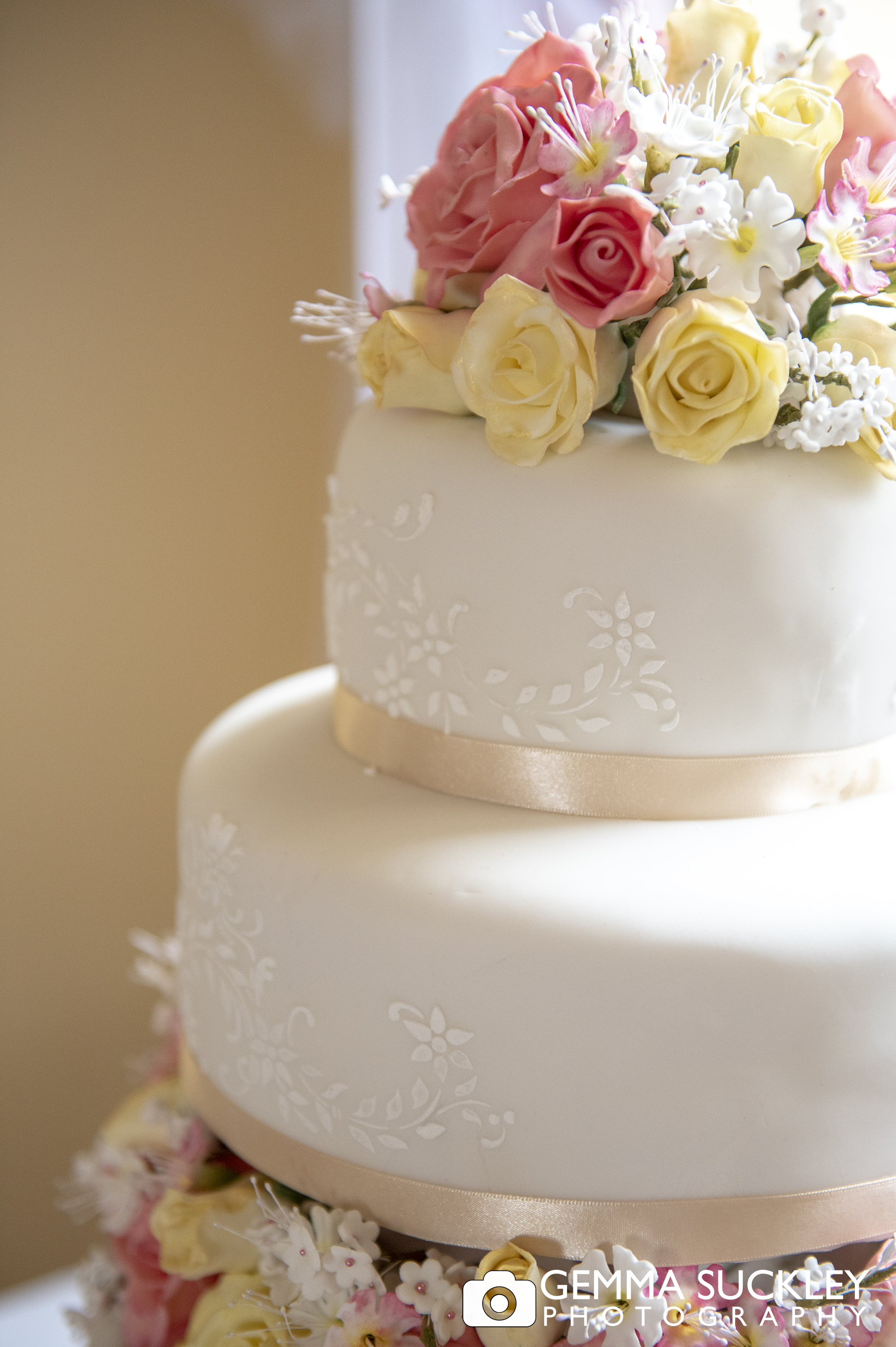 close up photo of a wedding cake topped with flowers