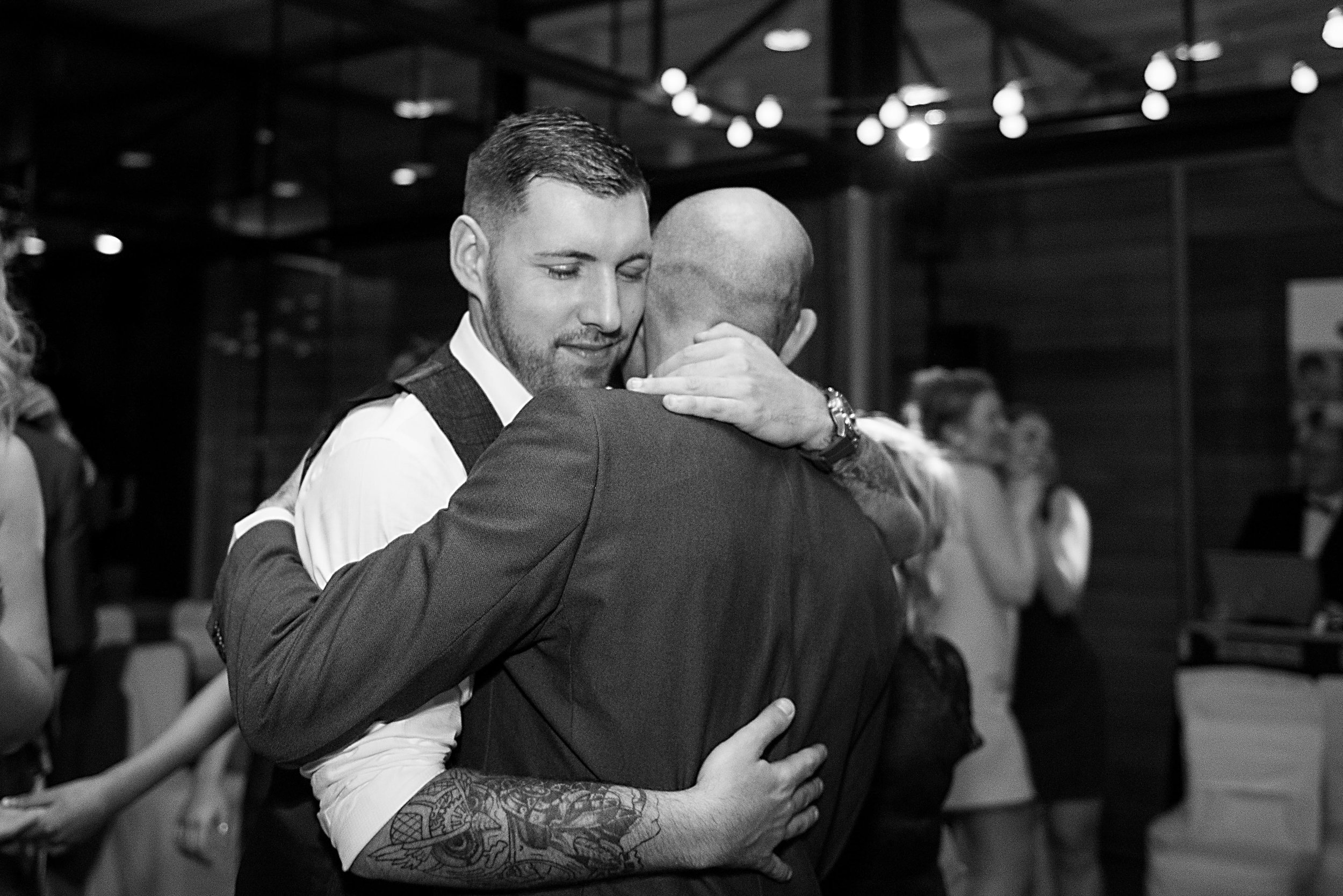 groom hugging his dad at utopia wedding reception