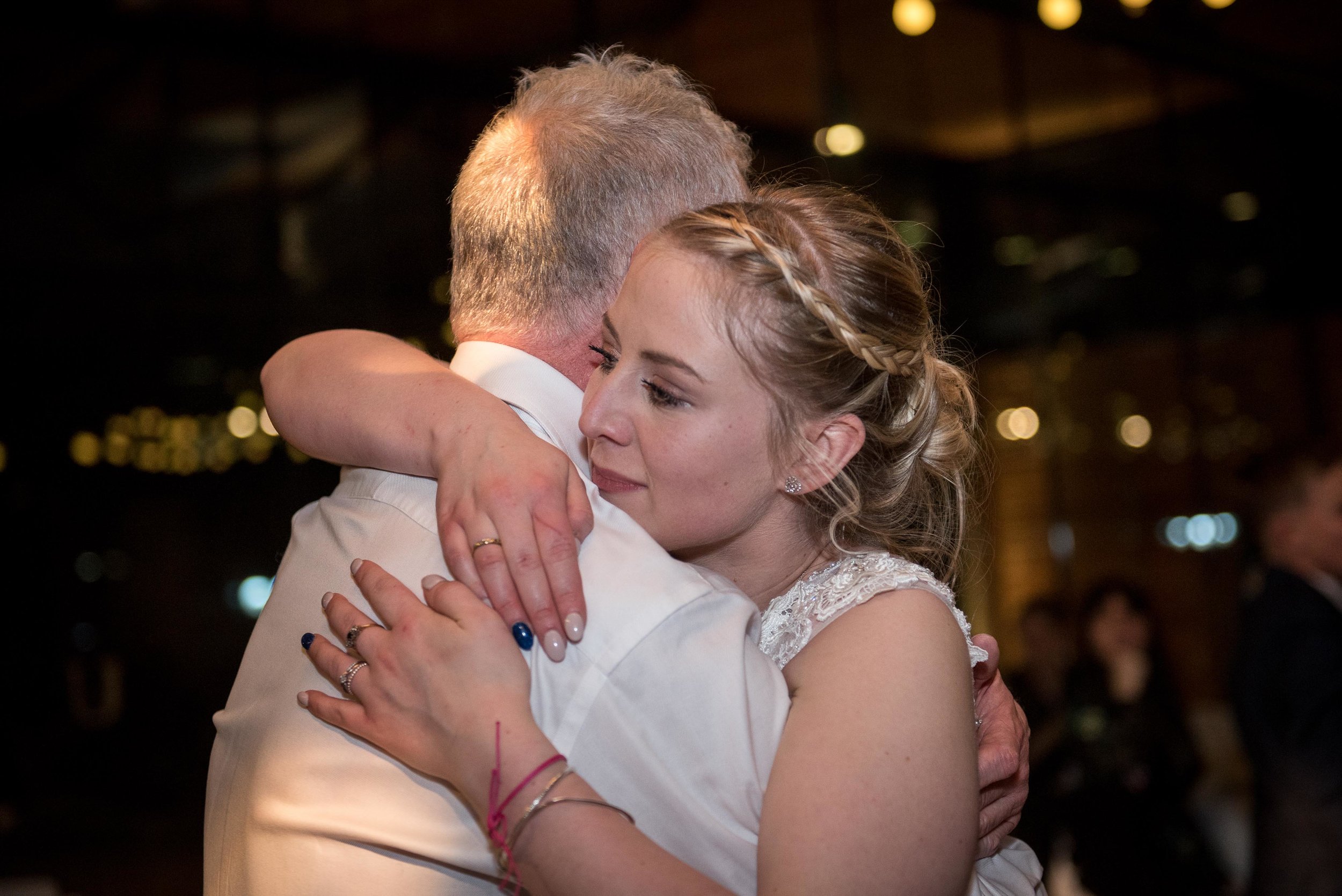 bride hugging her dad during wedding reception at utopia