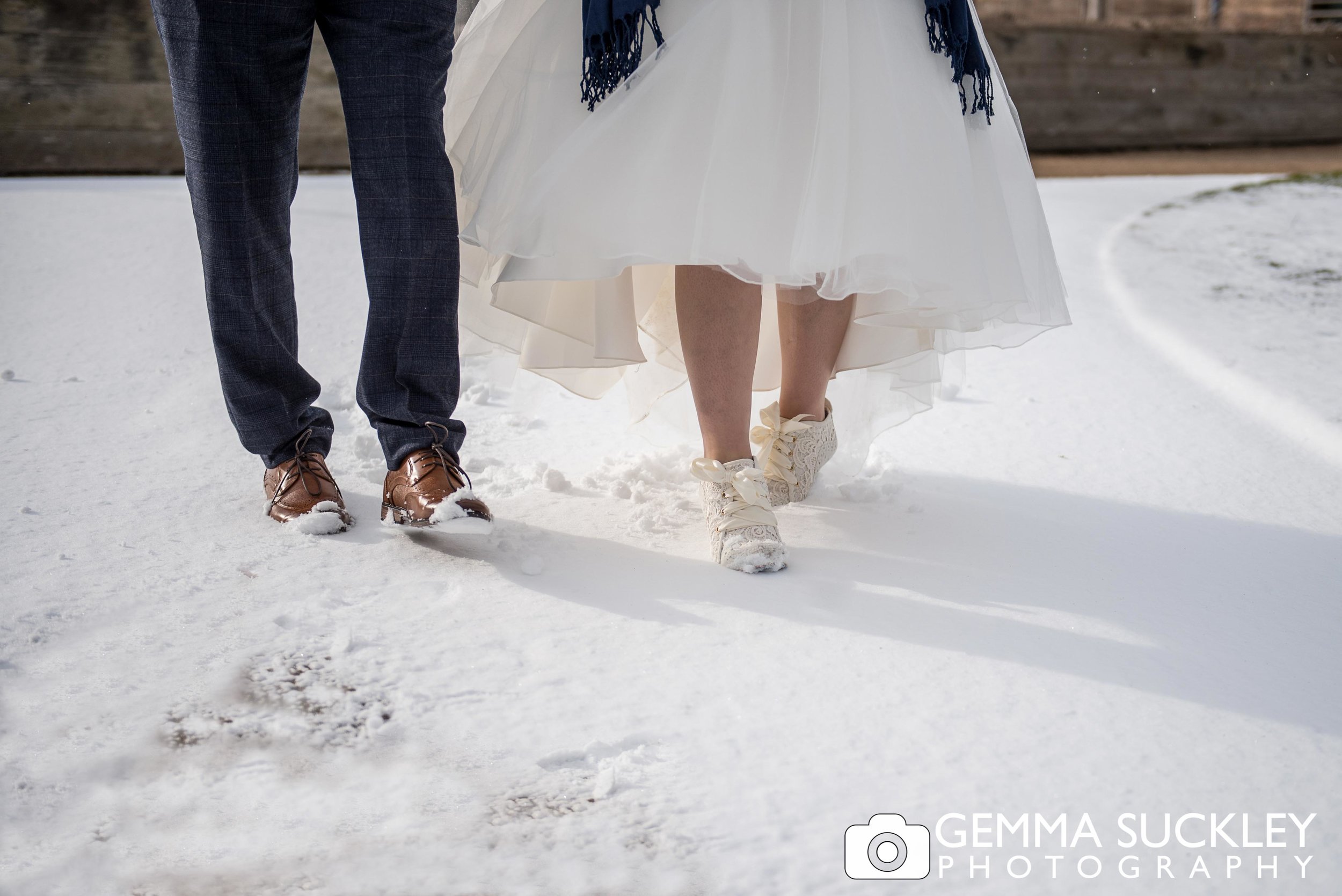 bride and groom walking in the snow at brought hall wedding