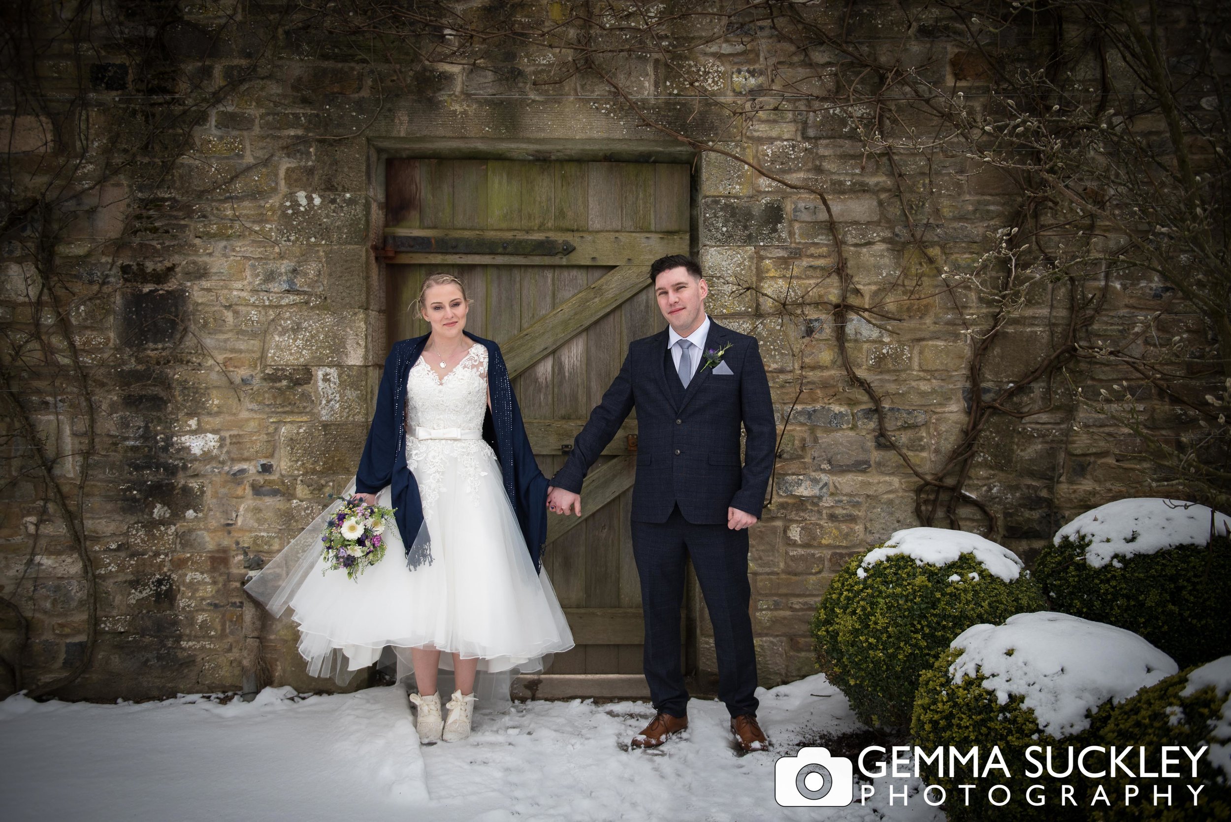 bride and groom holding hands at broughton hall