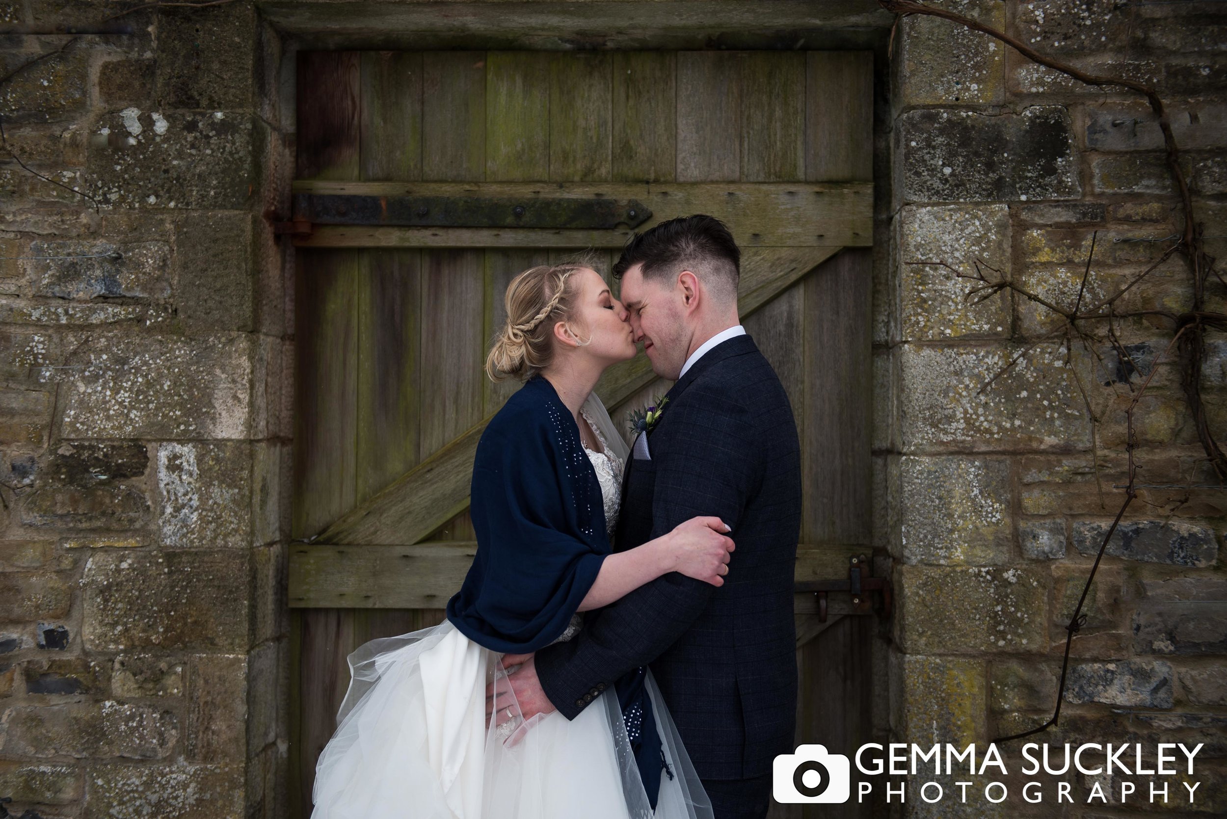 bride kissing groom at utopia at broughton hall