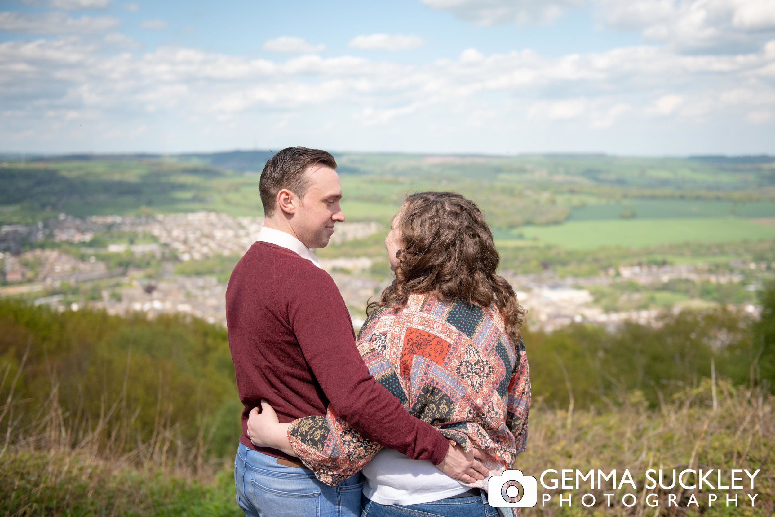 engaged couple looking out the view from the otley chevin
