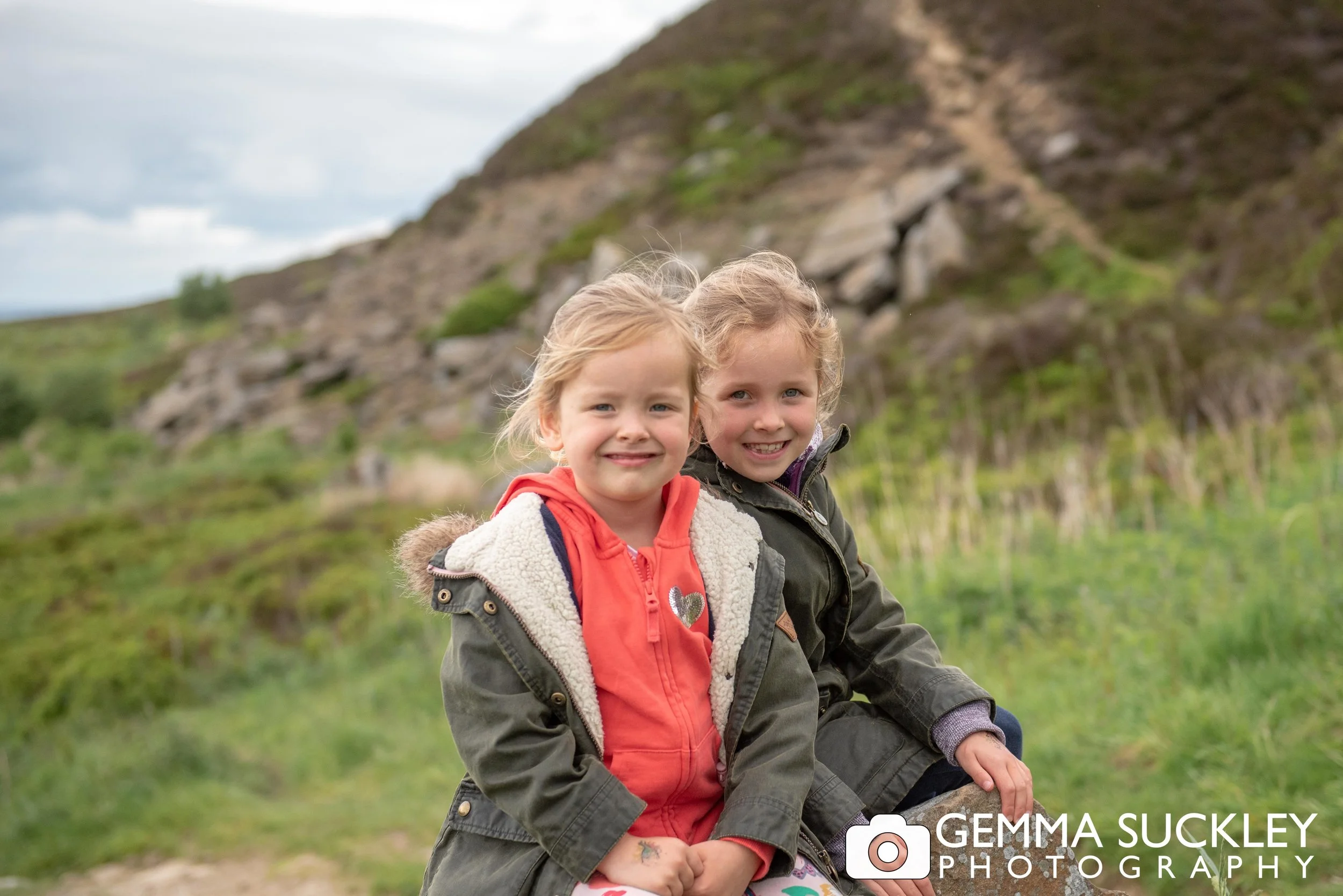 two little girls smiling for a family photo on hawotrh moor