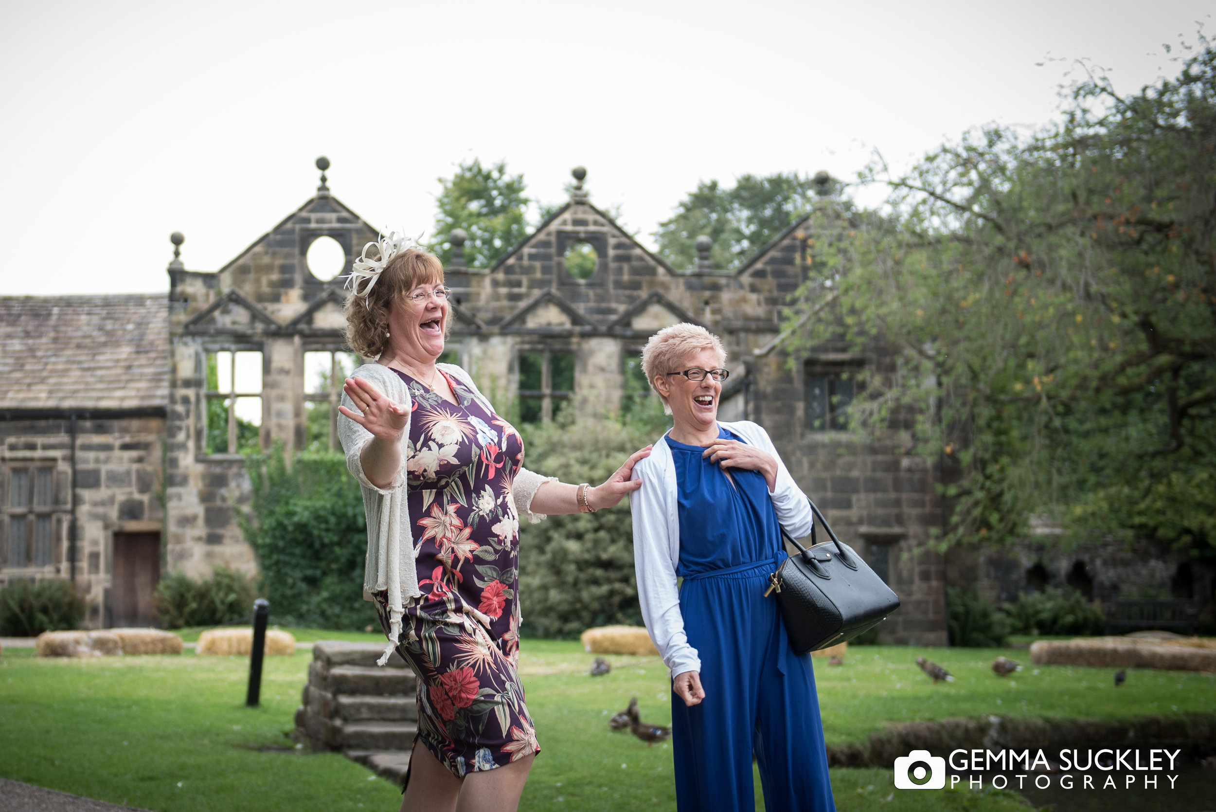 wedding guest laughing with east riddlesden hall in the background