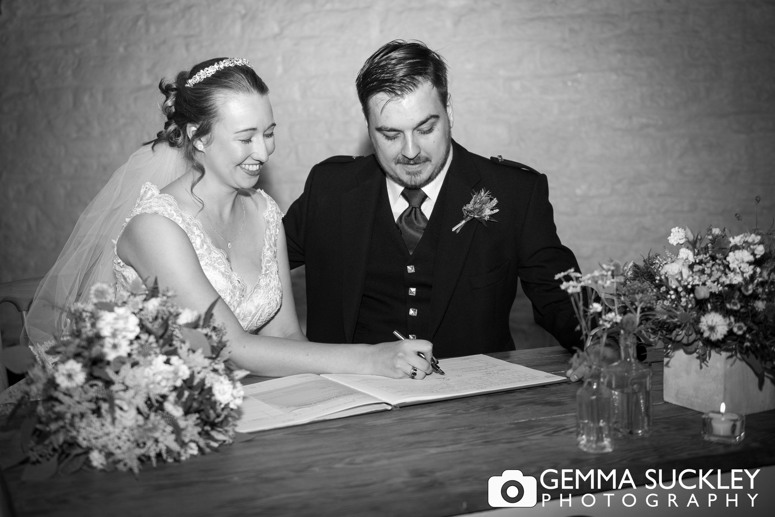 bride and groom signing the register at east riddlesden hall