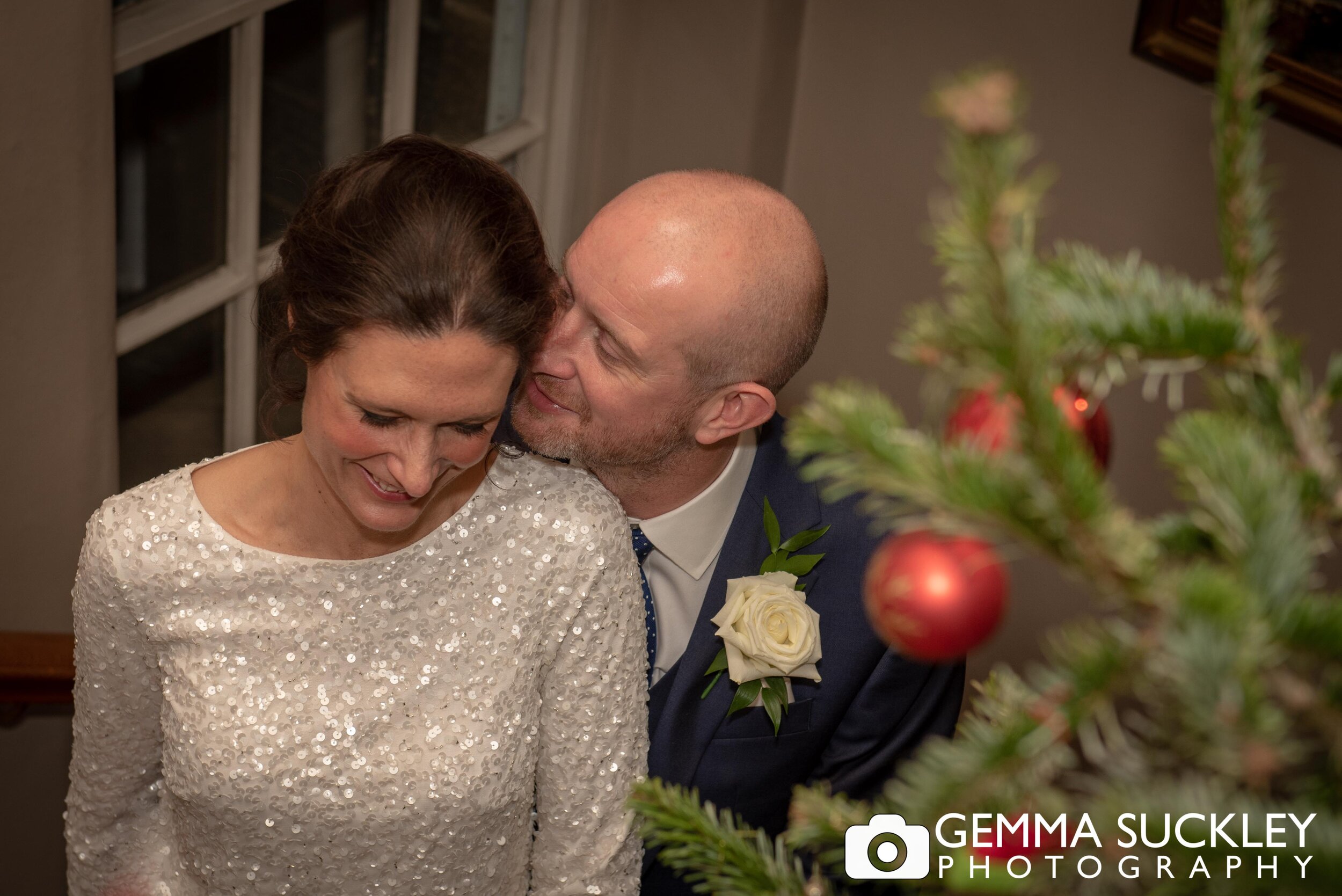 the groom kissing the bride at their christmas wedding