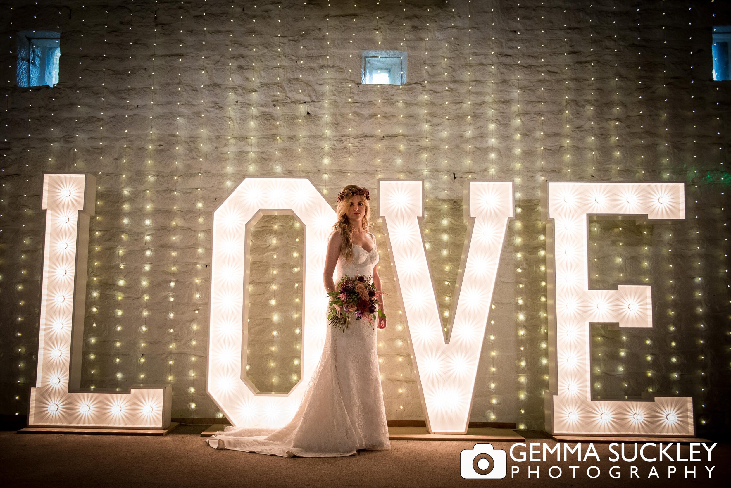 a bride with light up letters behind her at east riddlesden call