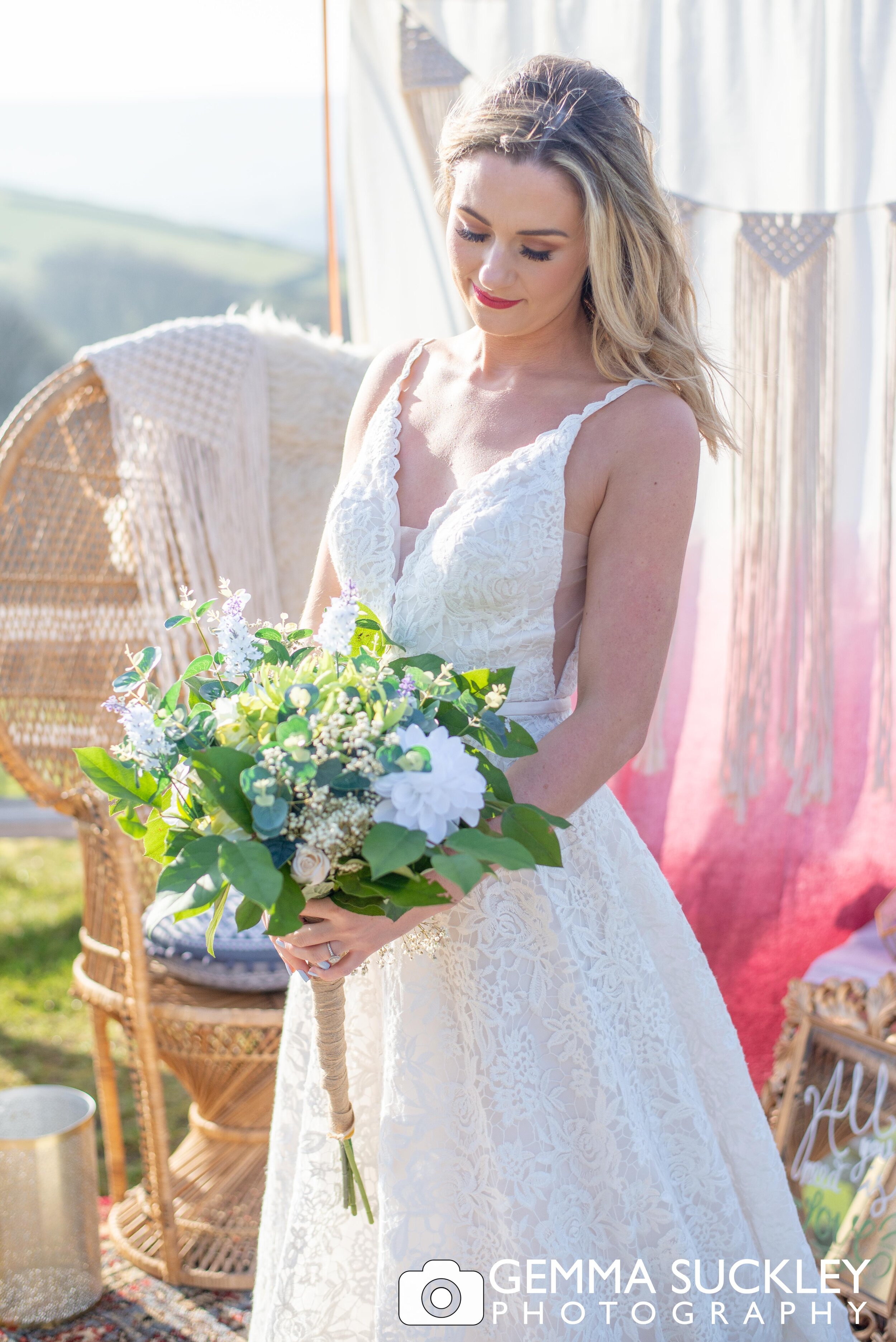 a bride in the sunshine holding a wedding bouquet 