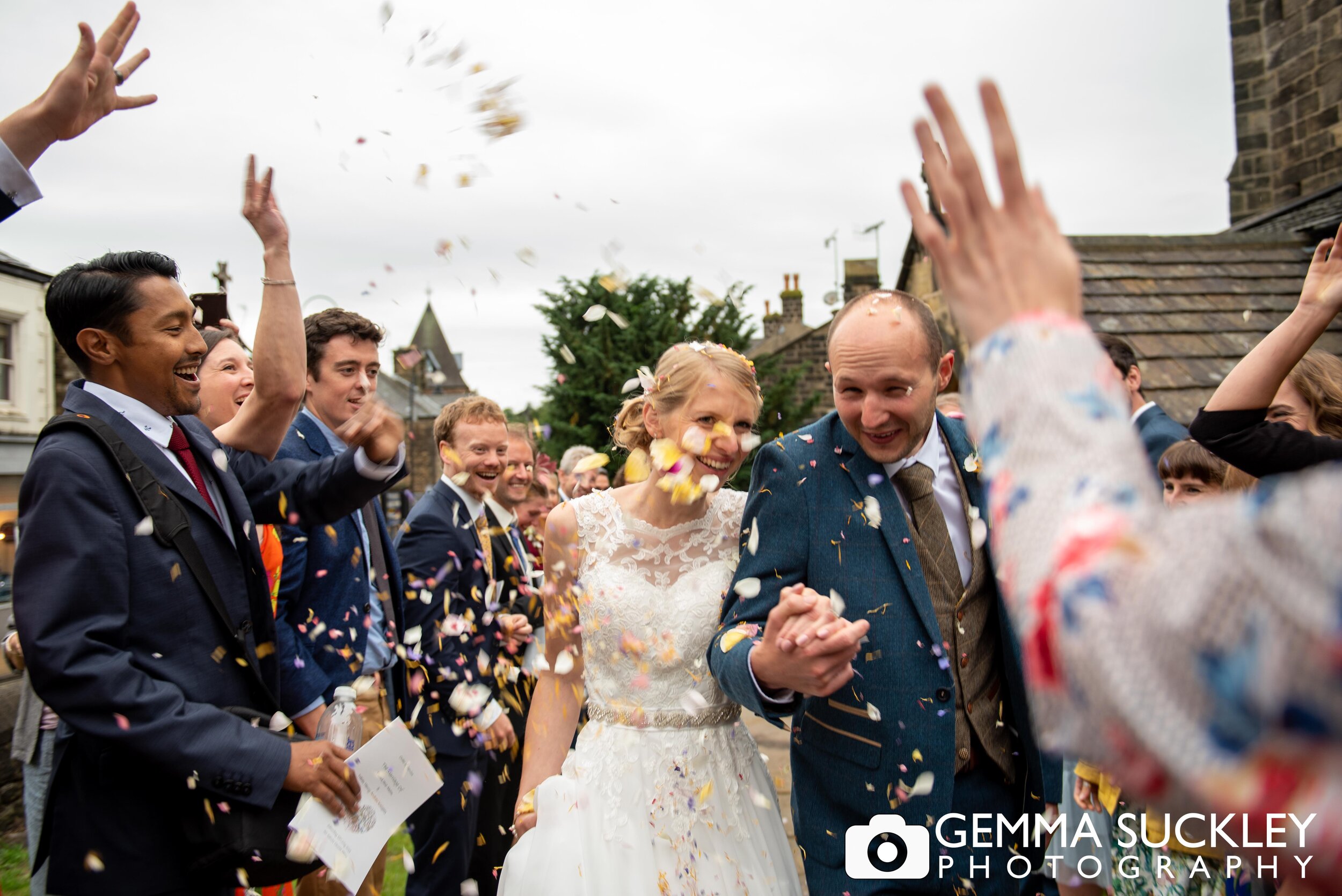 wedding guests throwing confetti at the bride and groom