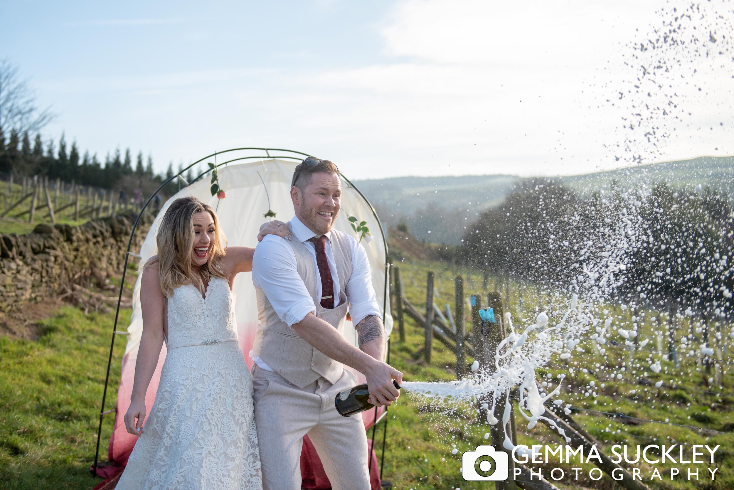 bride and groom with a bottle of flowing champagne 