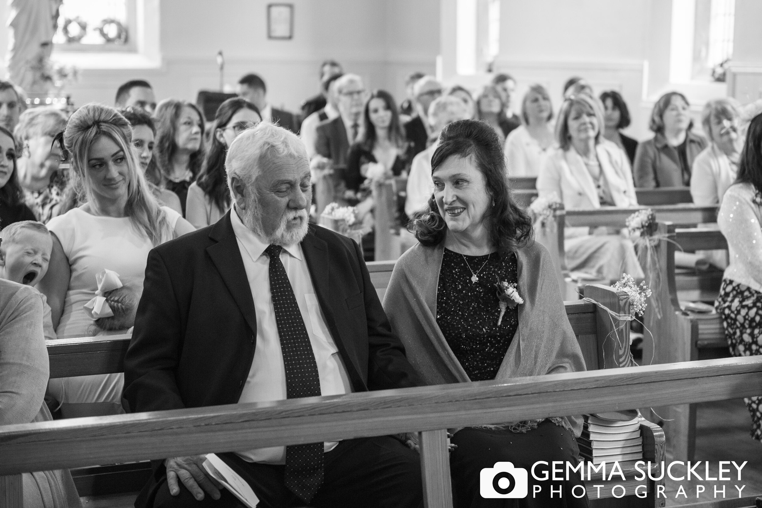 black and white documentary wedding photo of the guests in a small church in haworth