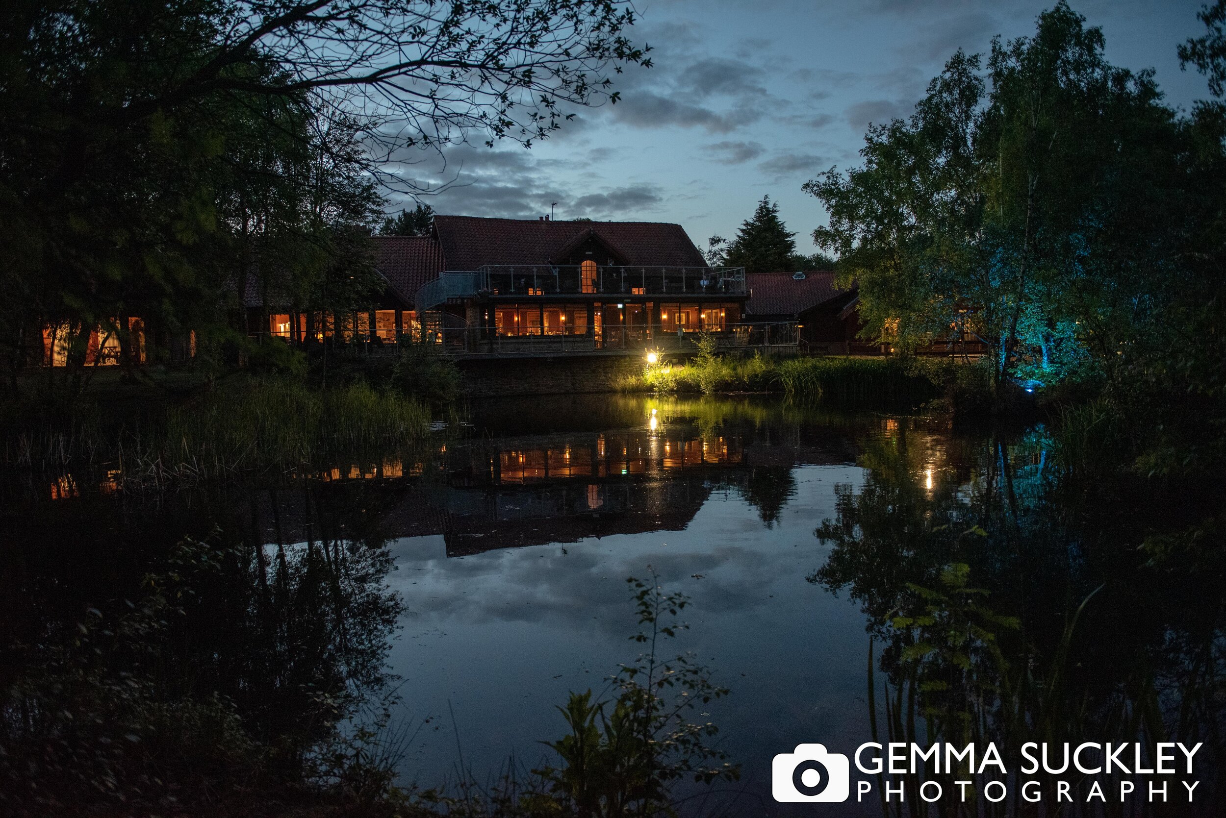 night time photo of the otley chevin hotel across the lake