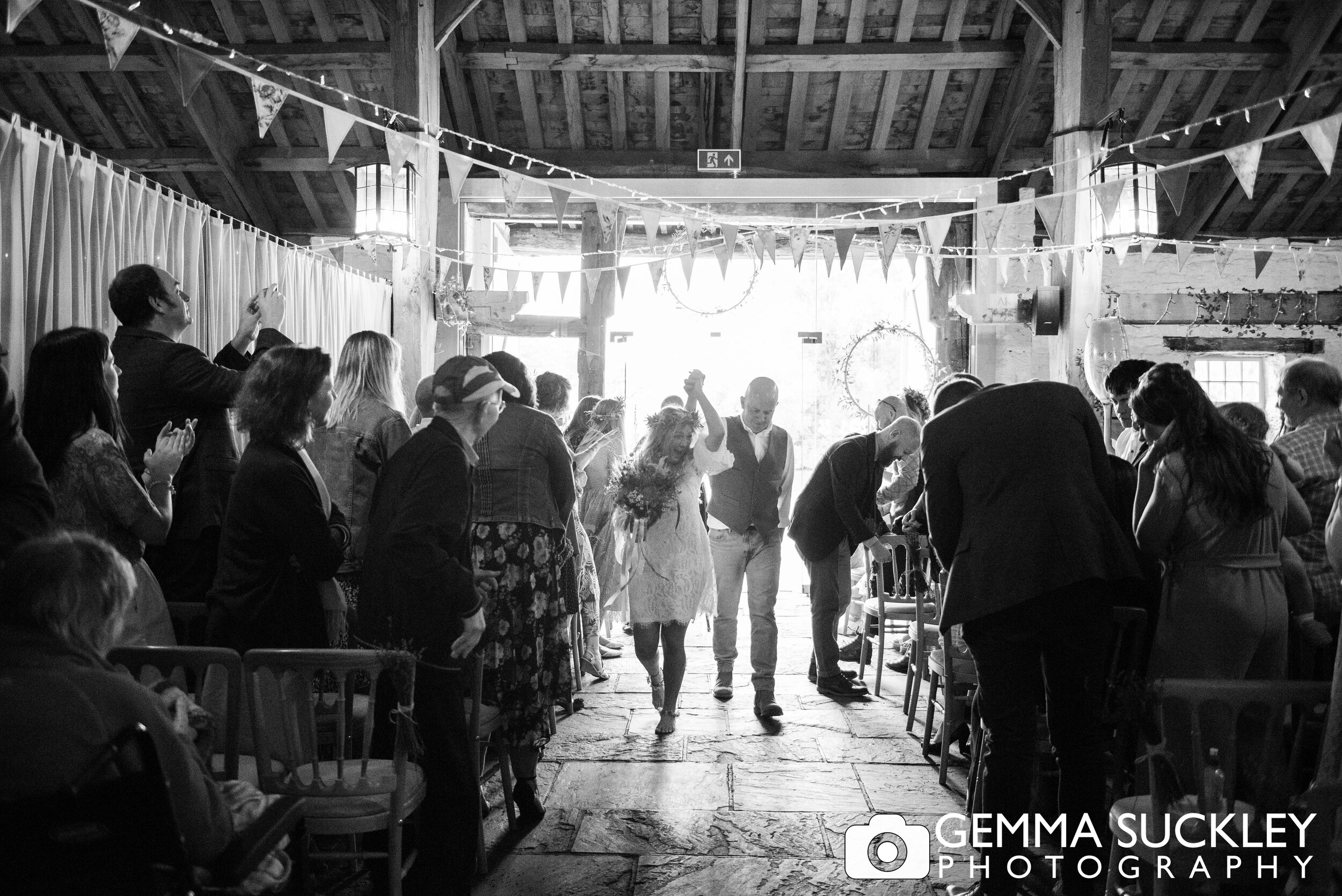 bride and groom dancing down the aisle in the barn at east riddlesden hall