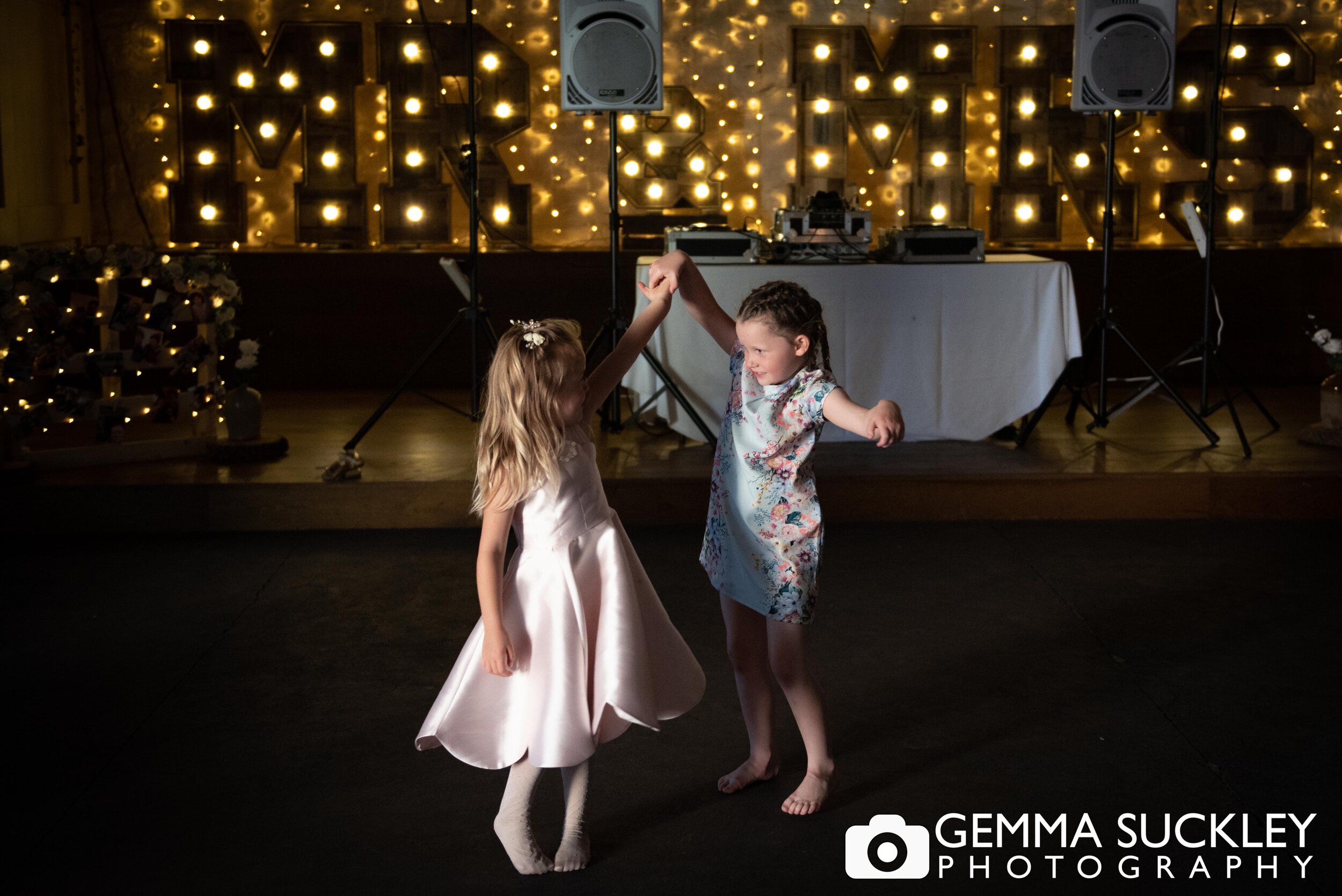 two little girls dancing in the barn at east riddlesden hall