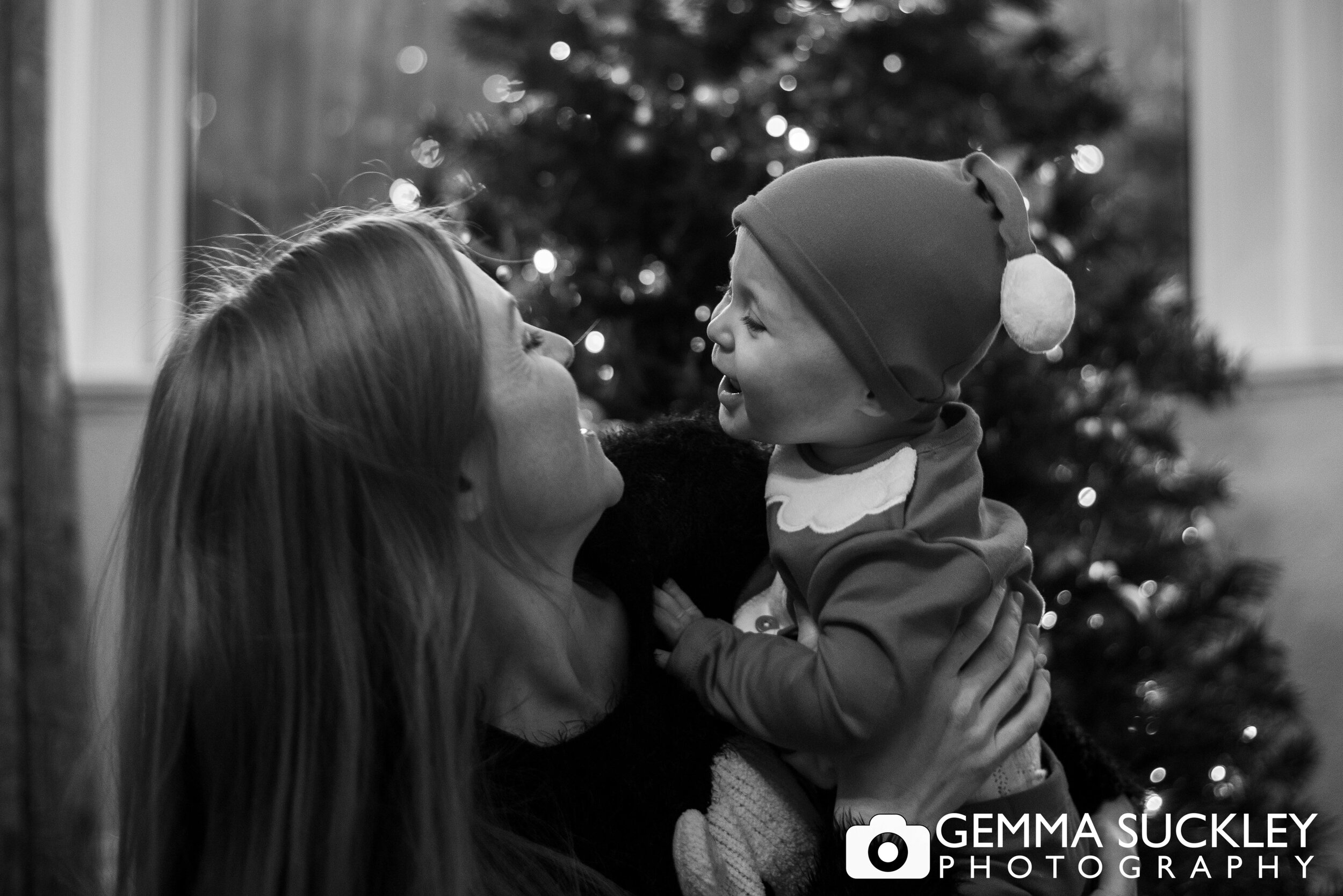 mum and baby in front of the christmas tree
