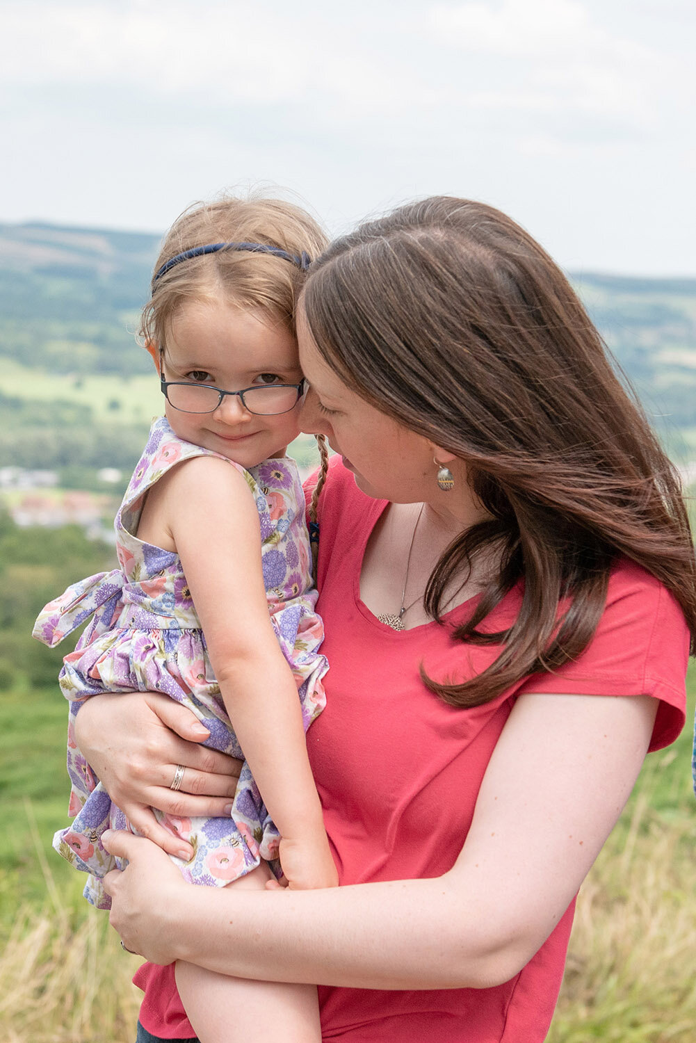 Mother and daughter cuddling with ilkley moor in the background