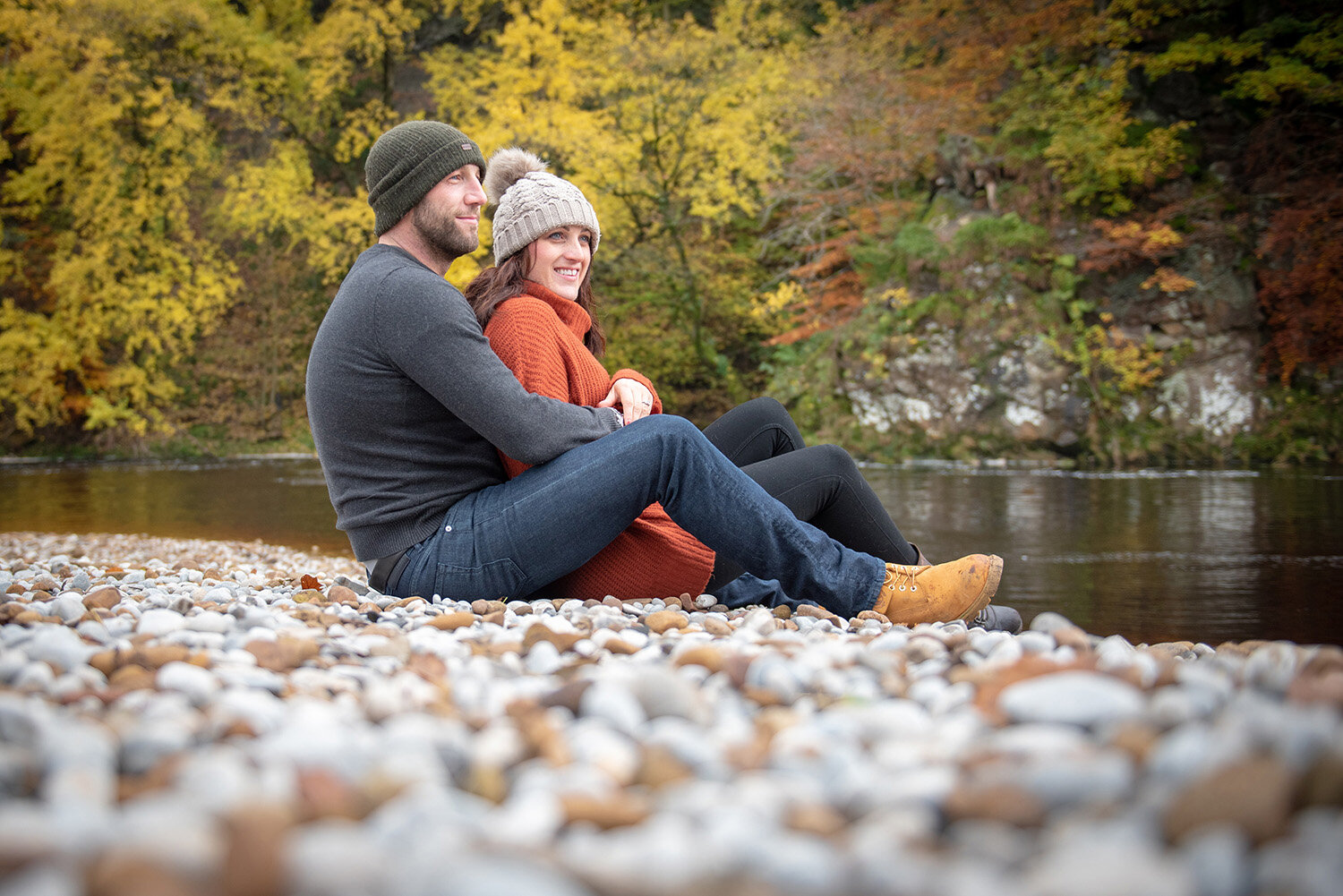 newly engaged couple at bolton abbey with autumn trees behind them