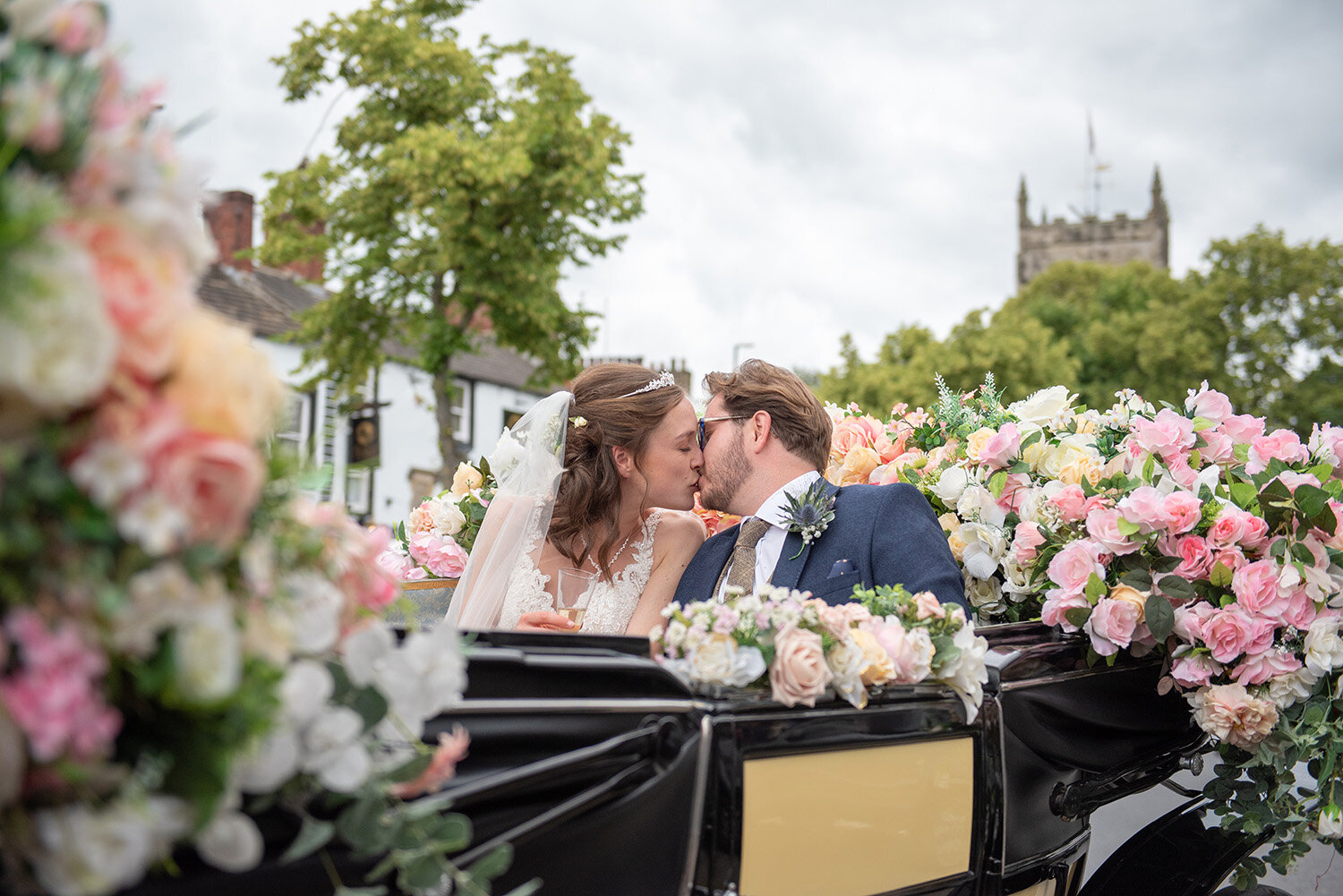 bride and groom kissing in a horse carriage on skipton high street