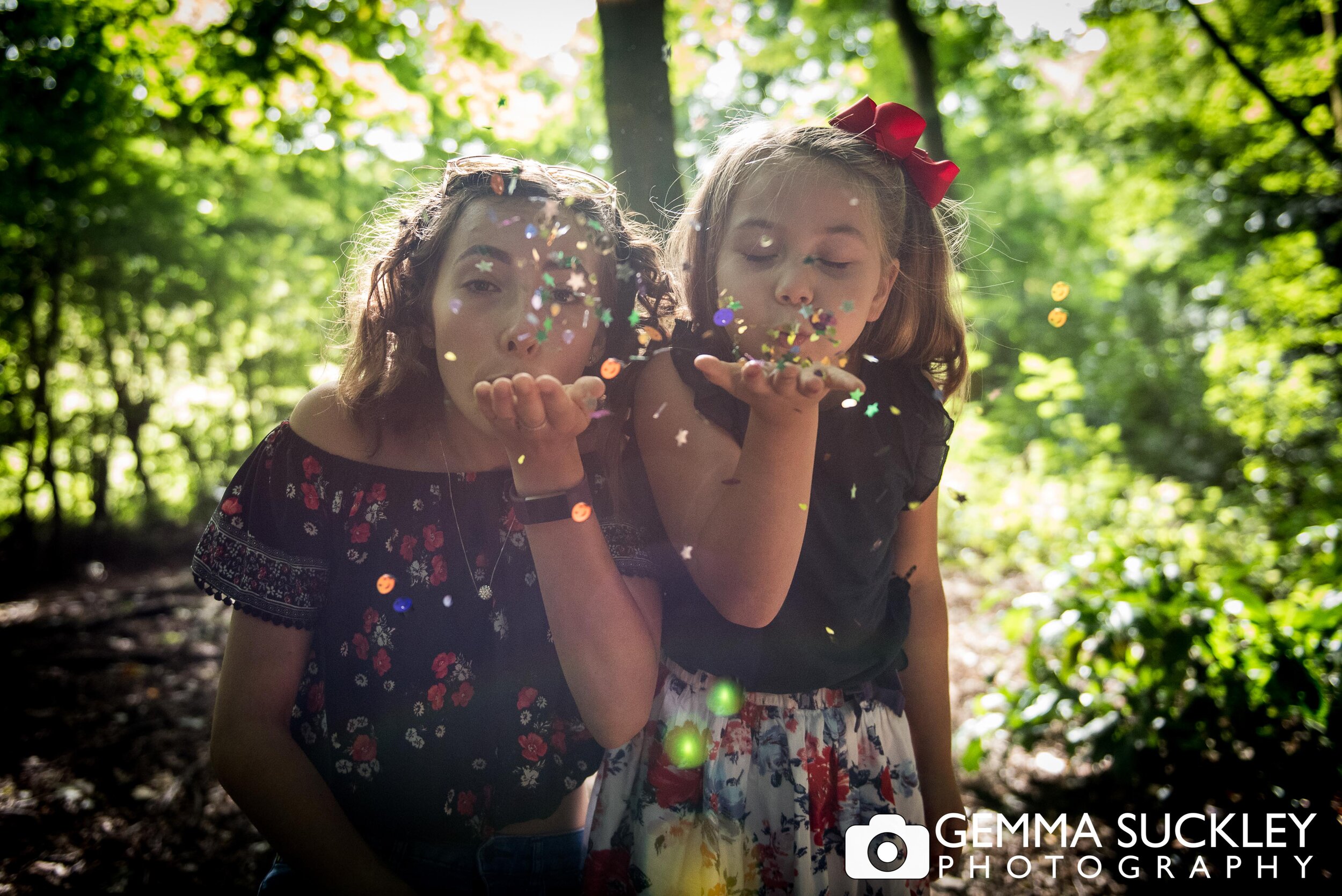 sister blowing glitters at the camera for a photo shoot