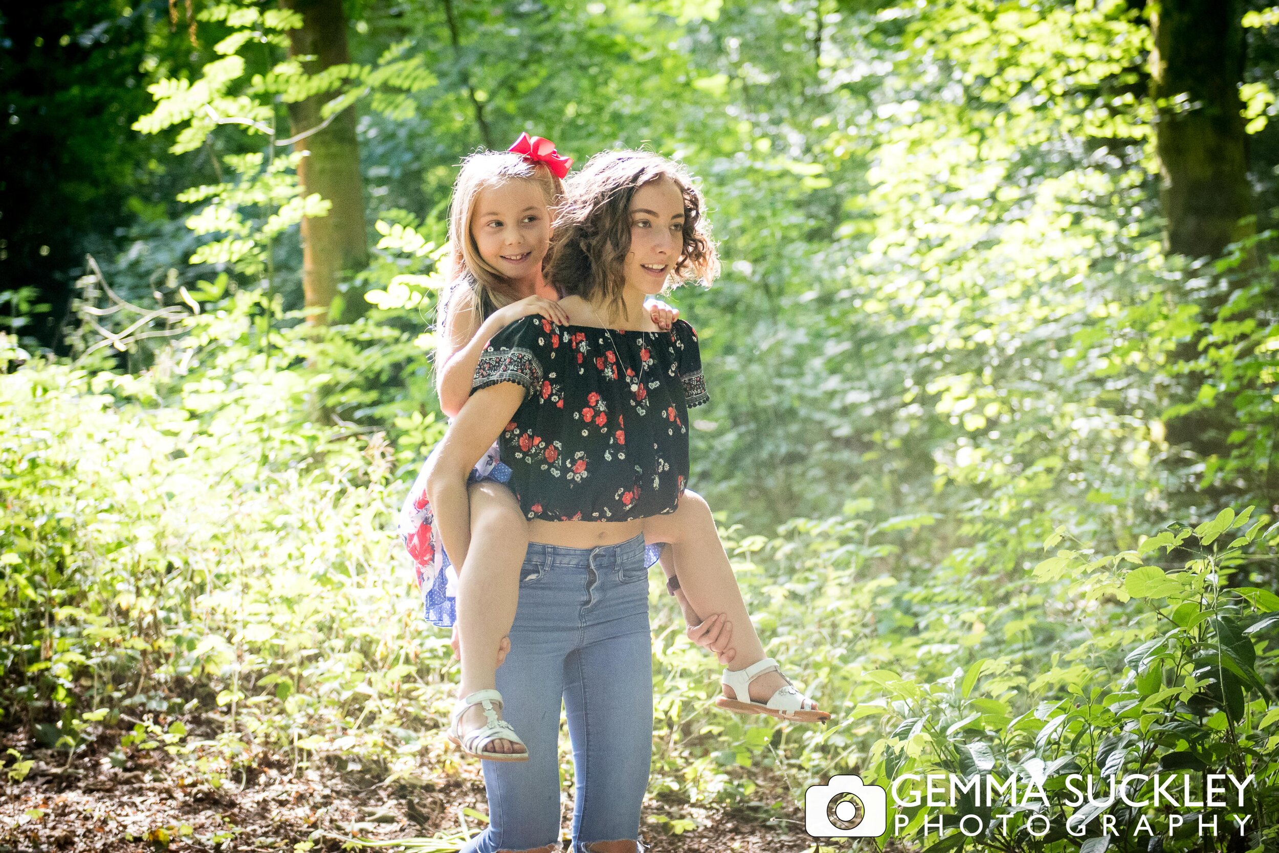a young girl piggybacking her little sister