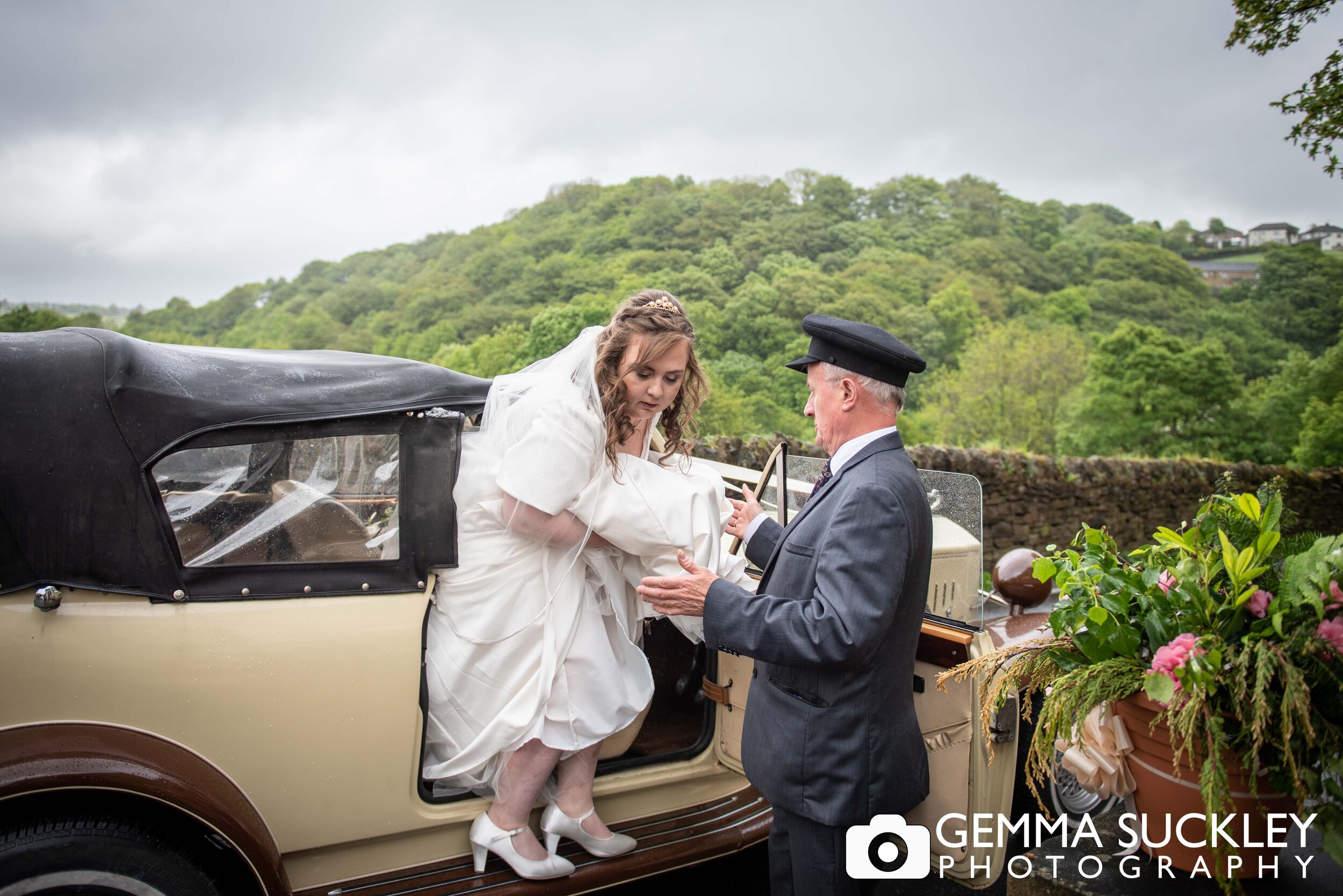 bride being helped out of a vintage wedding car