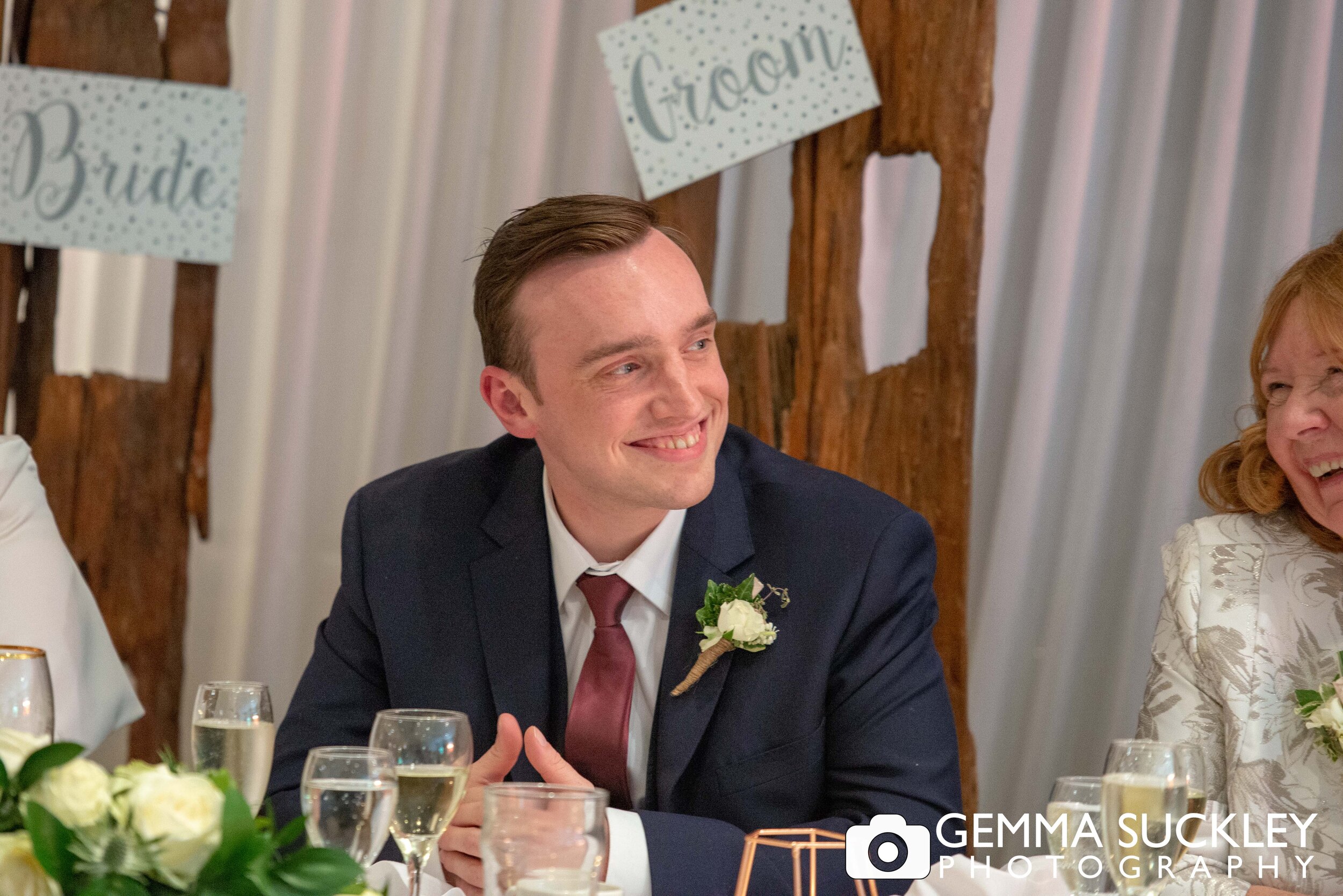 close up photo of the groom laughing at speeches