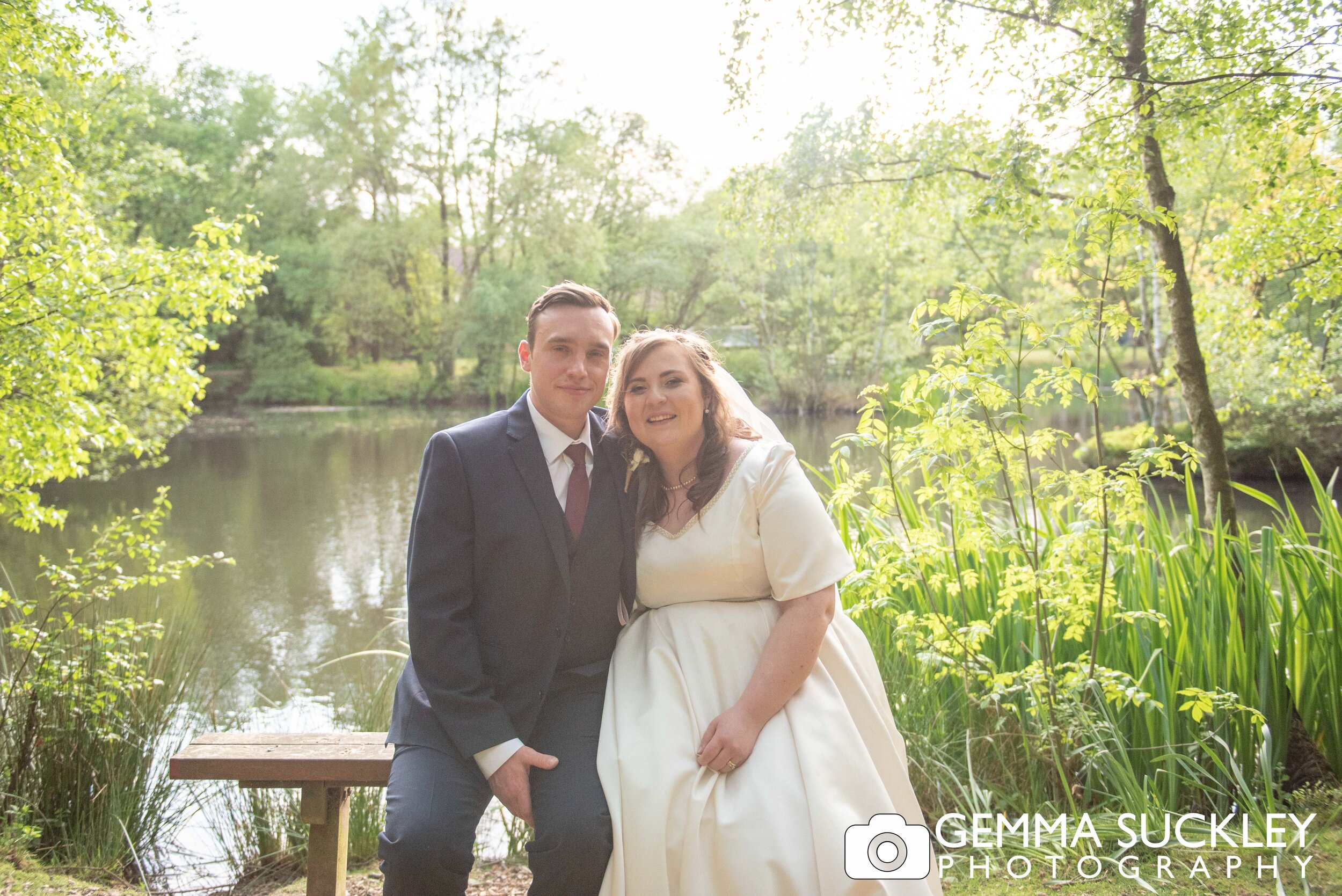 golden hour photo of the bride and groom in front of the lake at otley chevin country park hotel