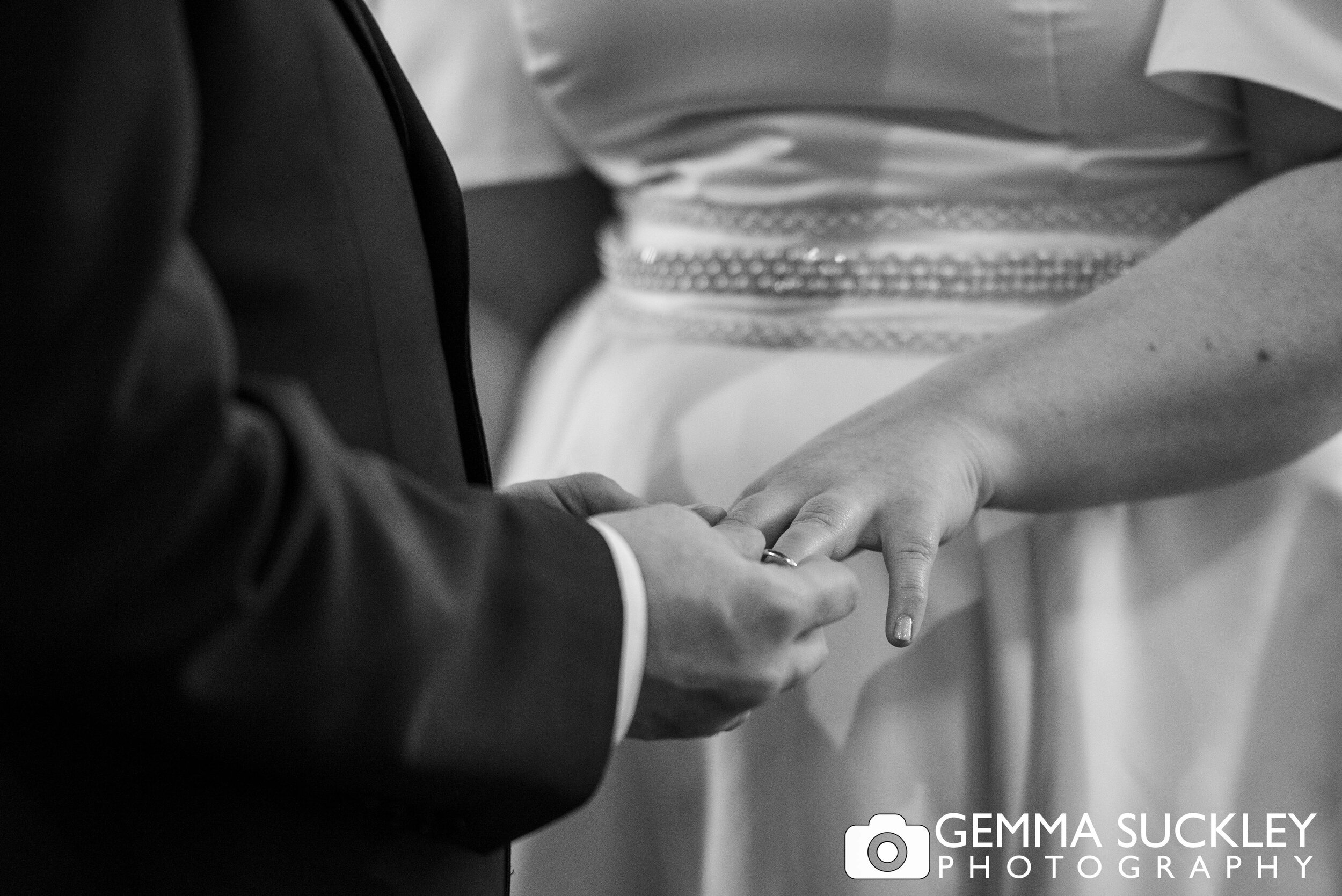 close up black and white photo of bride and grooms hands