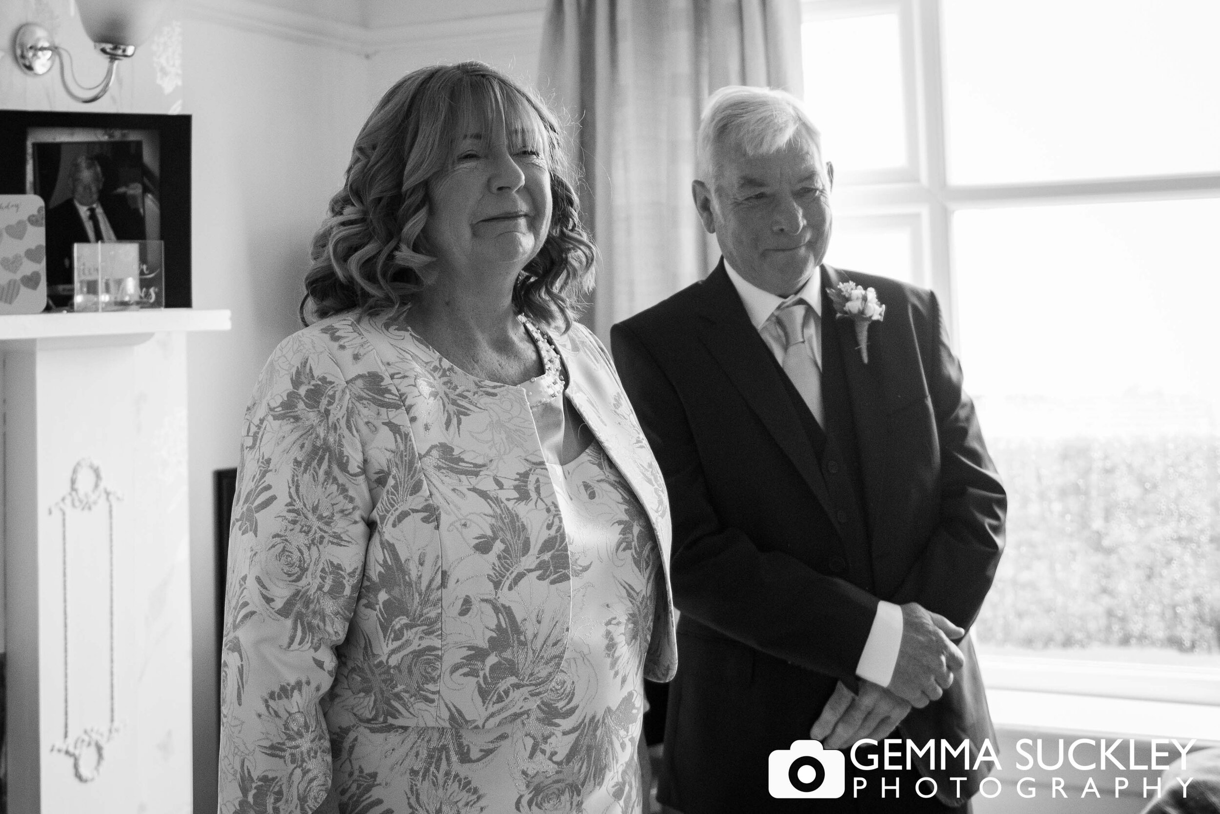 mother and father of the bride looking emotional as the bride enters the room