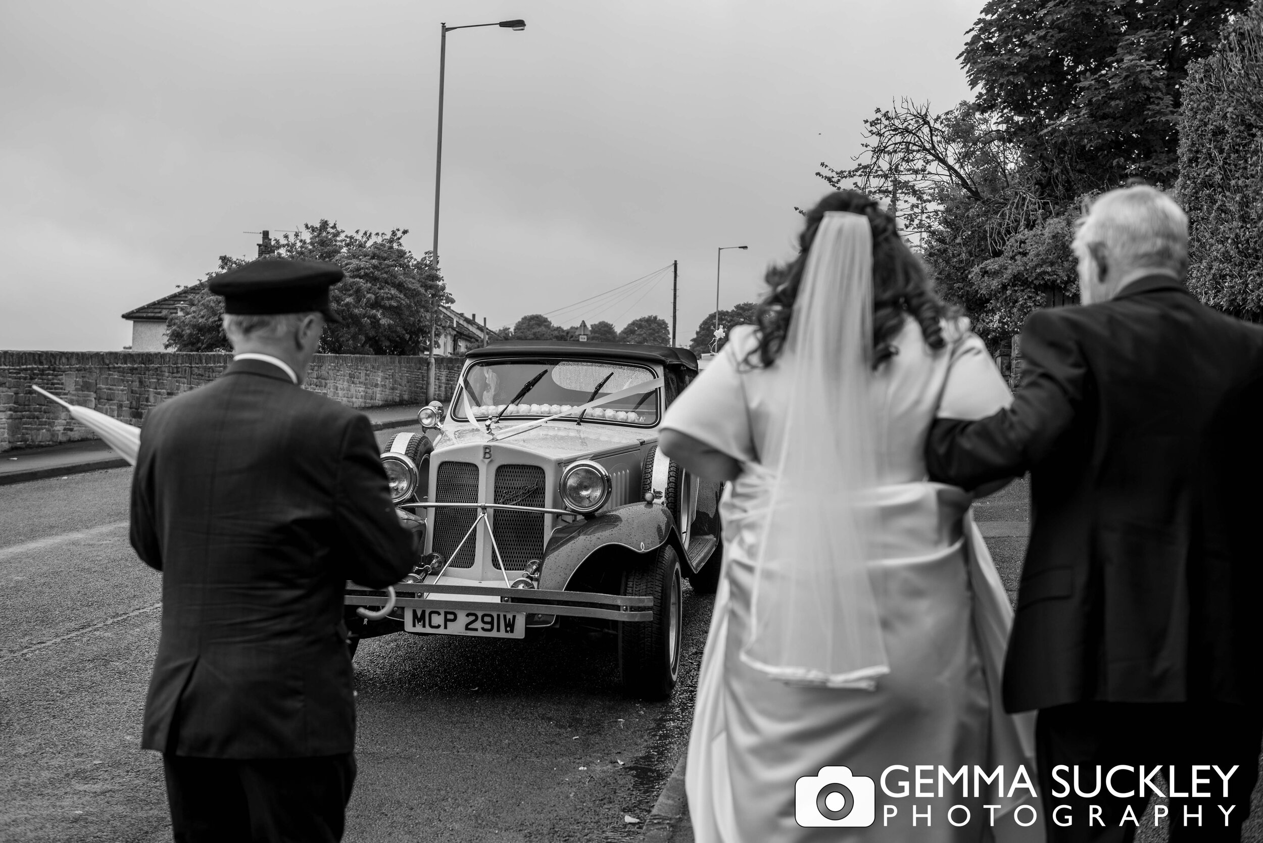 father of the bride walking his daughter to a vintage wedding car