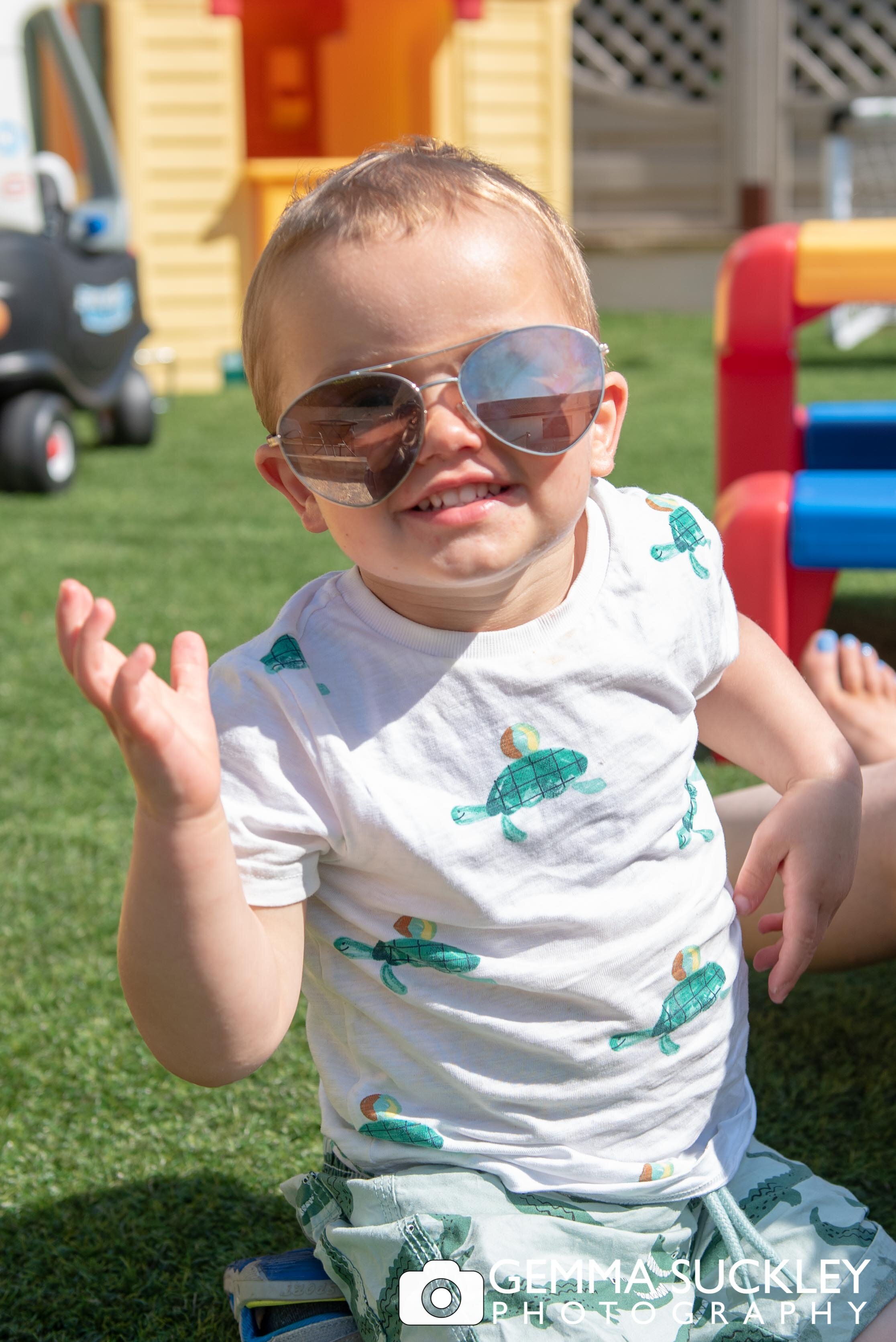 funny photo of a little boy in oversized sun glasses