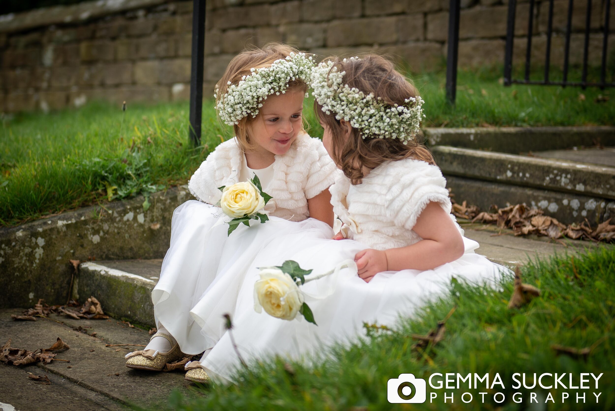 natural wedding photo of two flower girls looking at each other