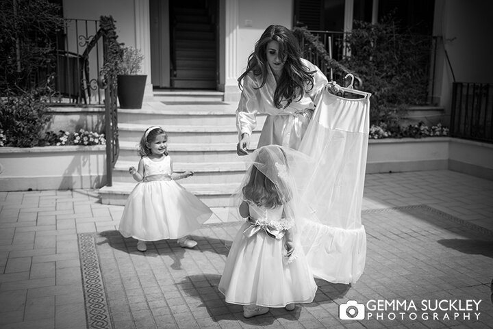 flower girls playing with the brides veil