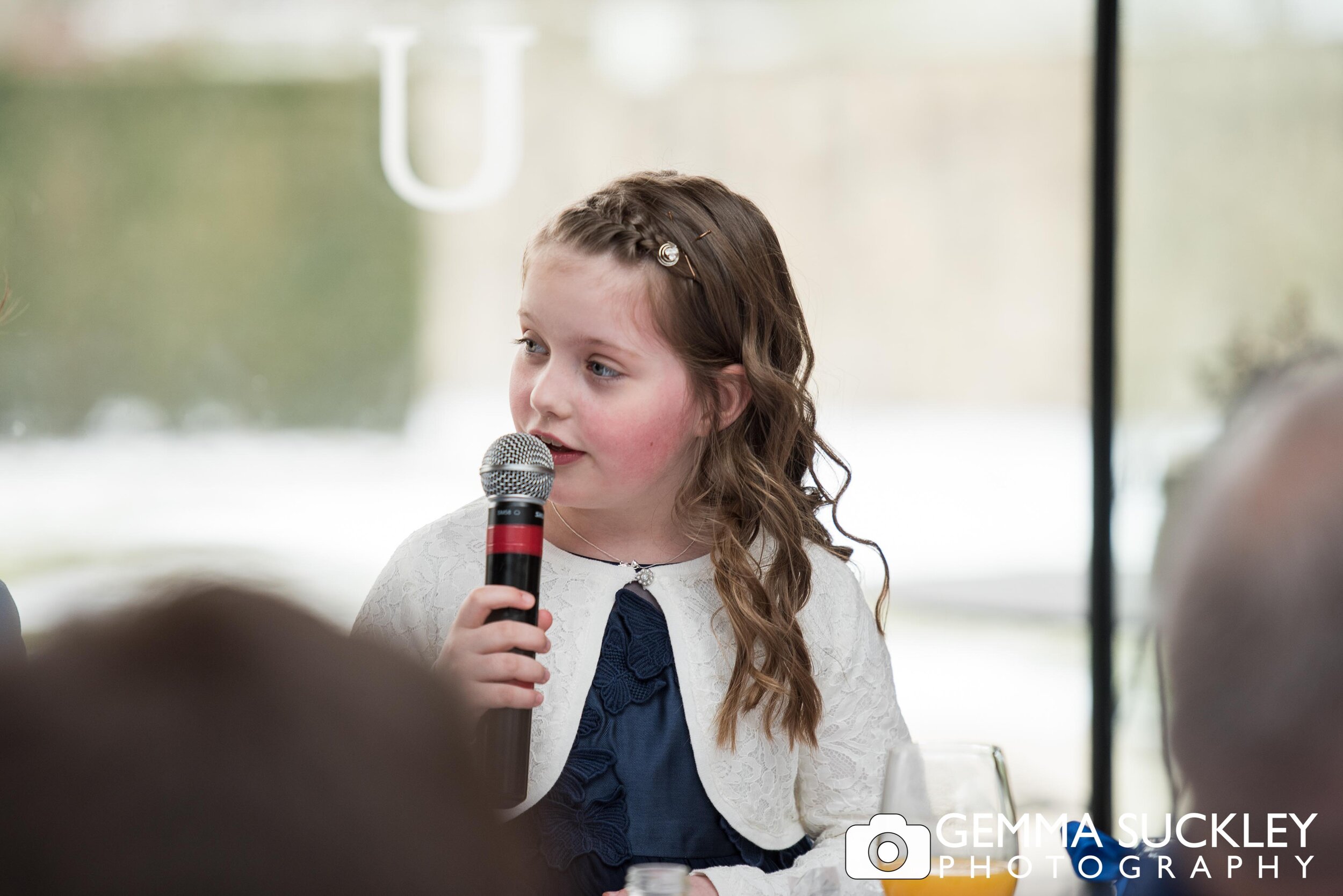 little girl making a speech at her parents wedding
