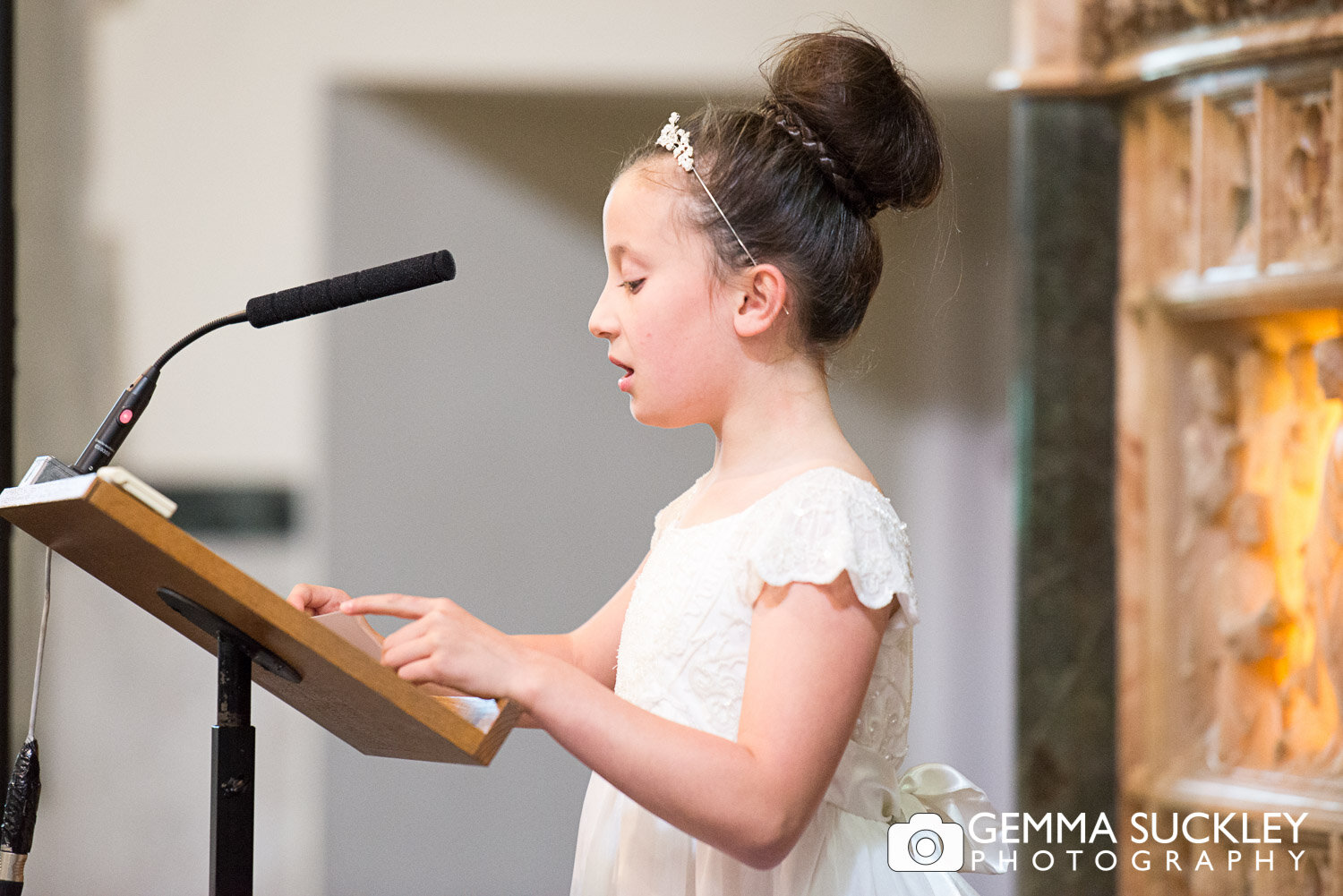 flower girl doing a reading during her parents wedding ceremony