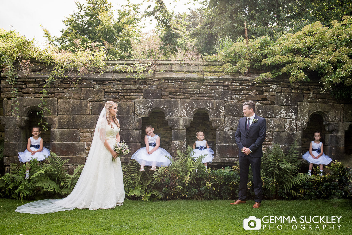 bride and groom with their flower girls at east riddlesden hall garden