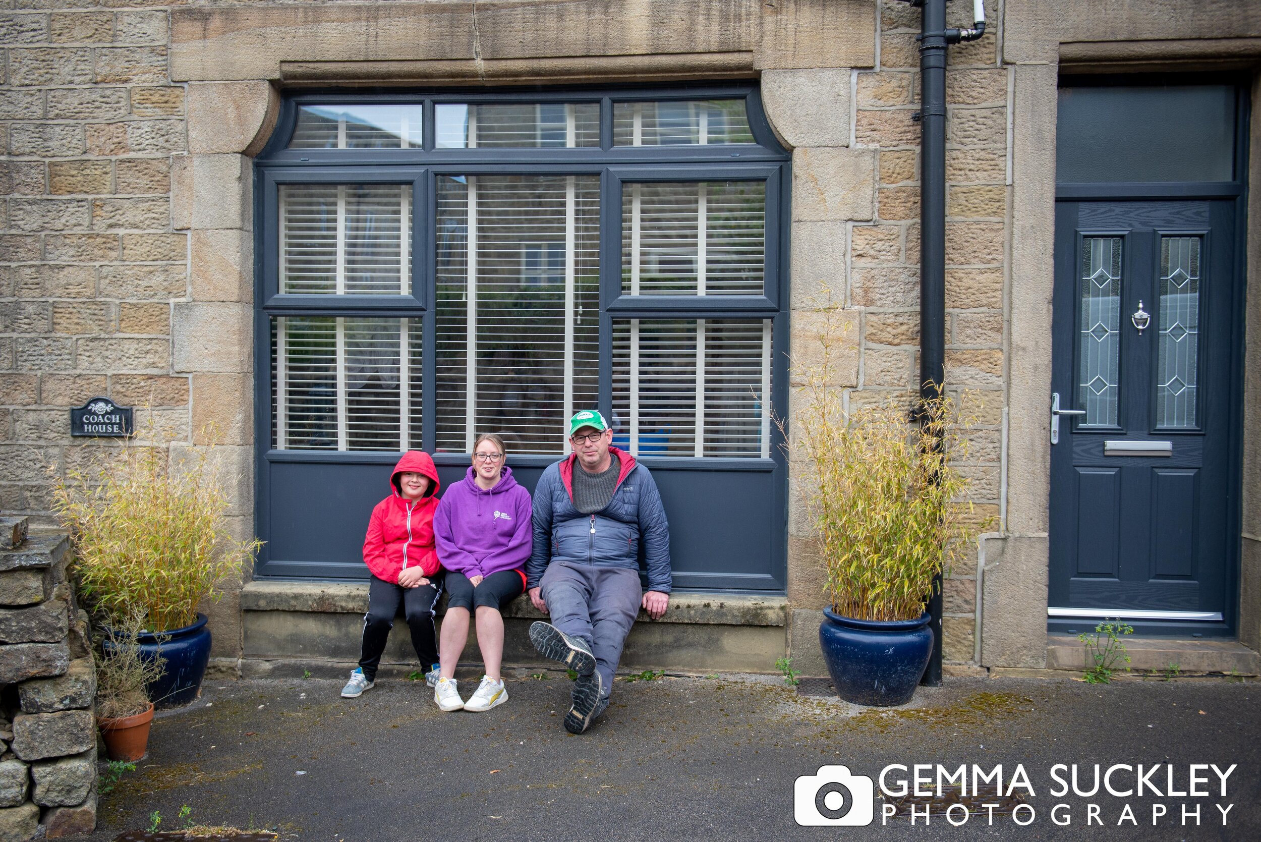 family sitting outside their house of a doorstep portraits
