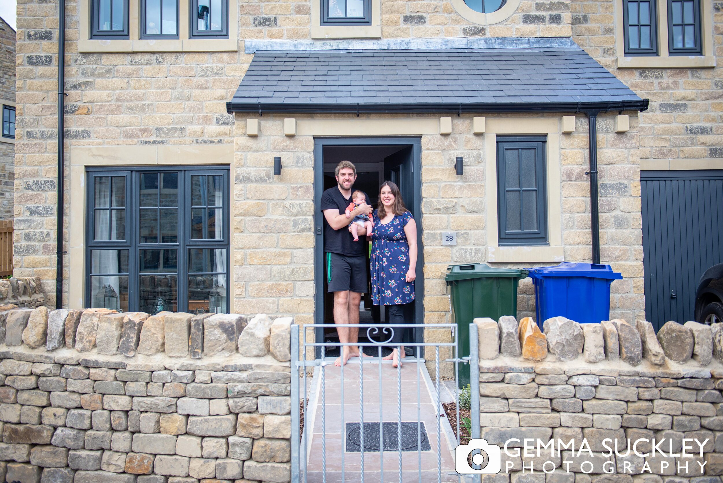 cononley couple and their new born smiling for a doorstep portrait 