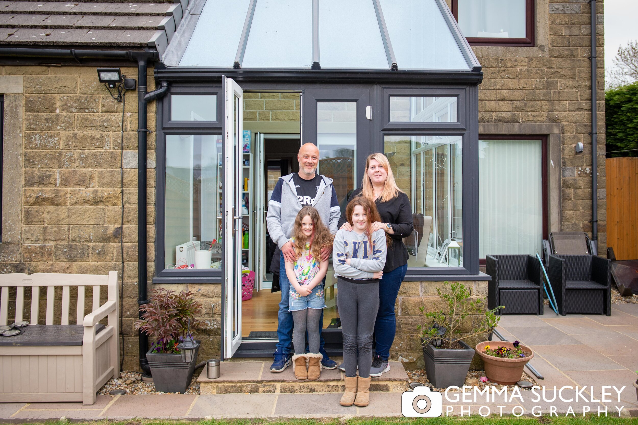 a doorsteop portrait of a couple and their two daughters during lock down