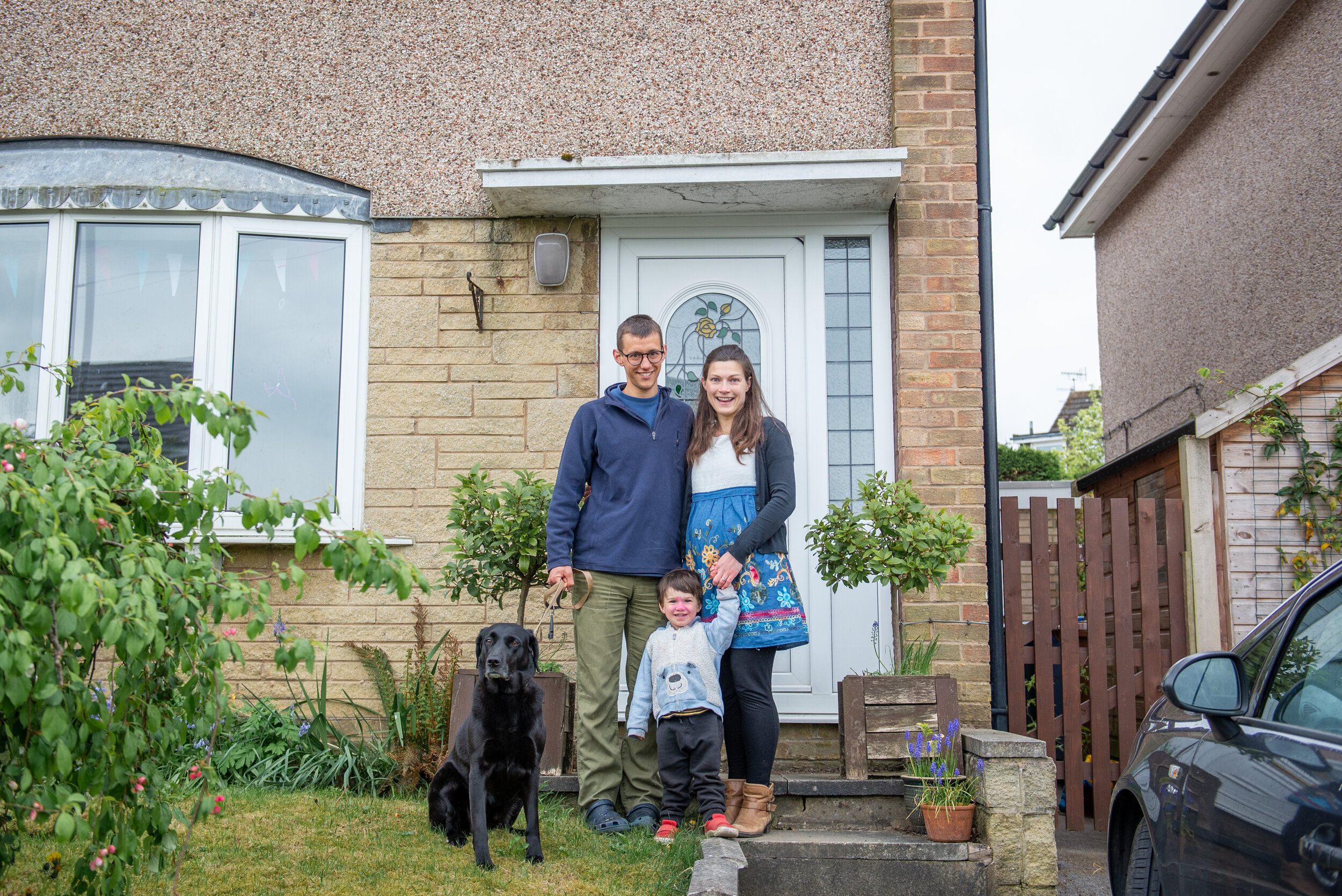 a family and the dog smiling for a doorstep portrait in cowling
