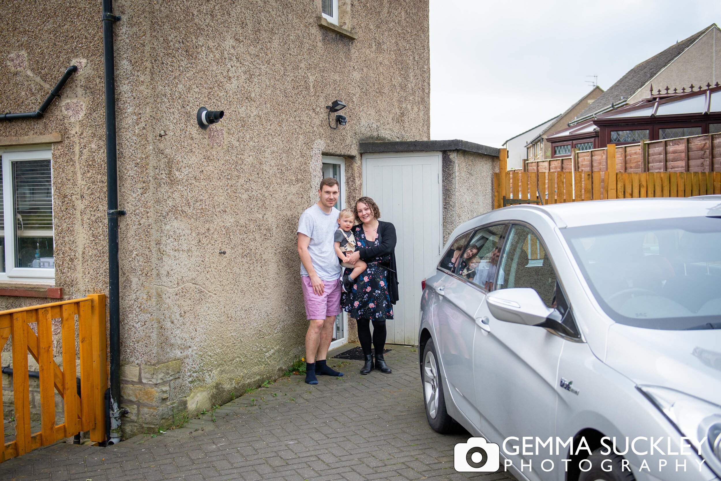 a young couple with the baby smiling for a doorstep photo in glusburn