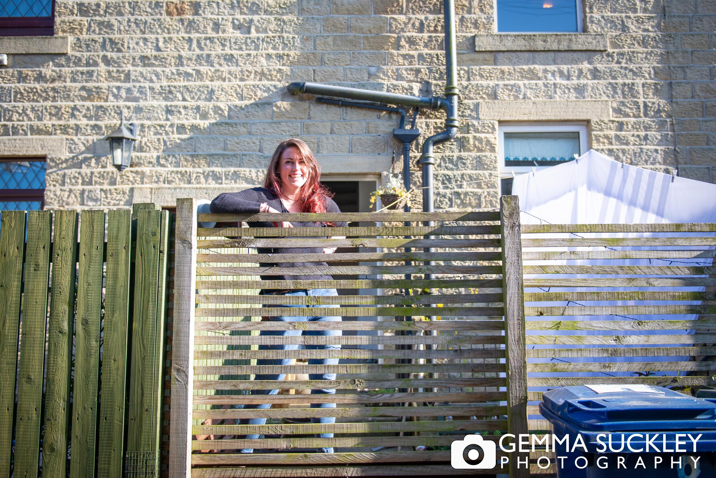 a doorstep photo on a girl looking over her fence in sutton