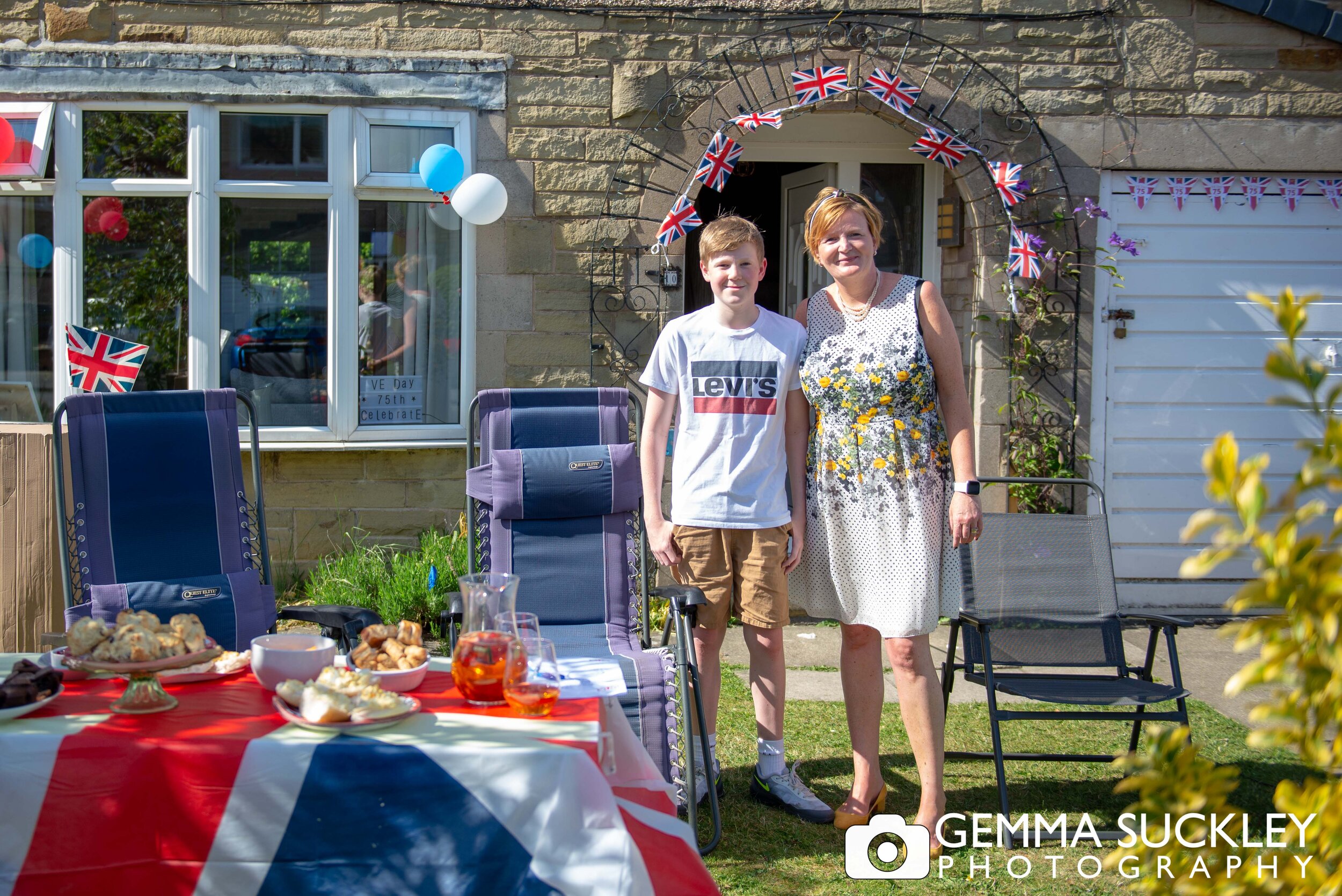 a woman and her son in their garden on ve day