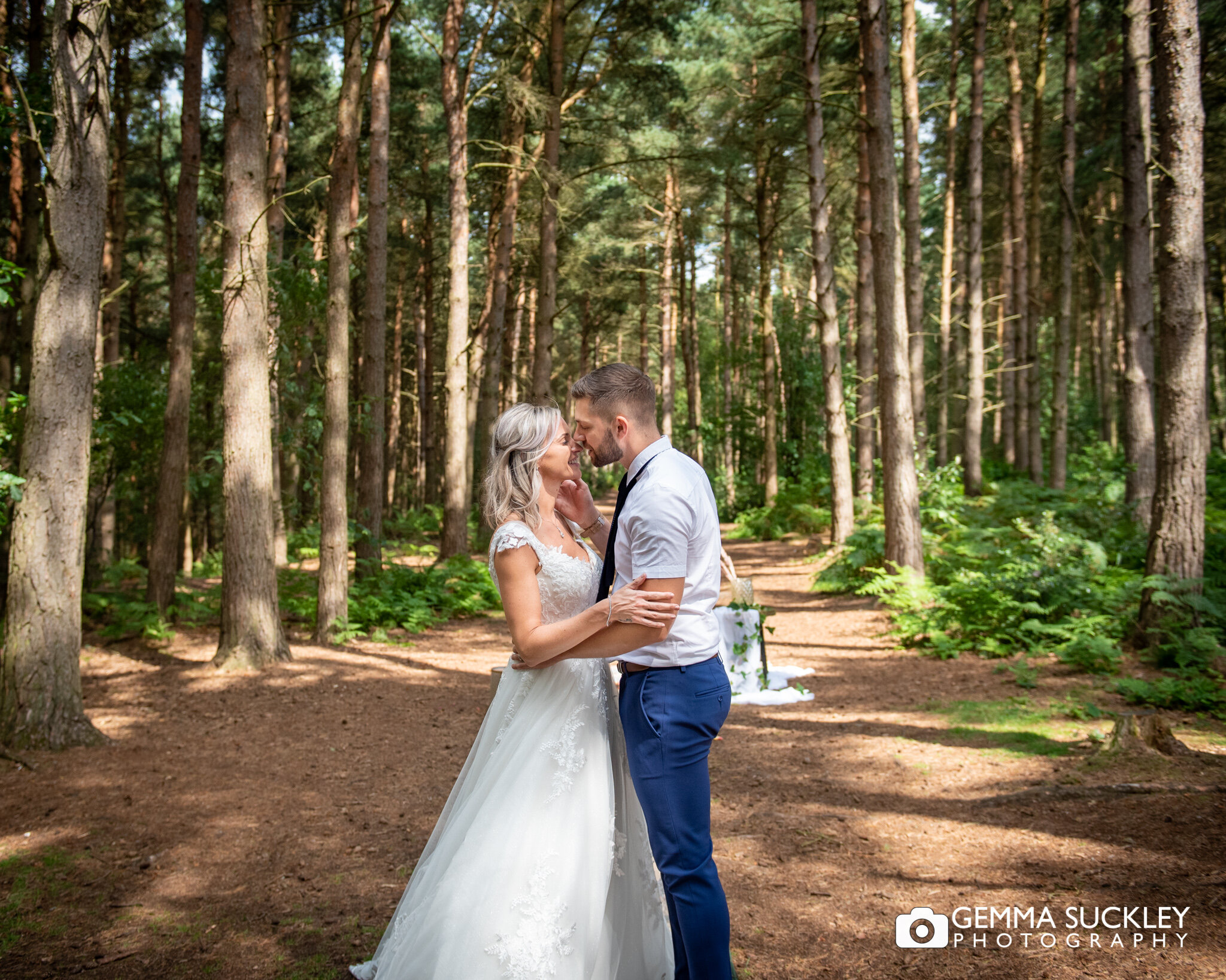 a bride and groom kissing in the woods after the vows