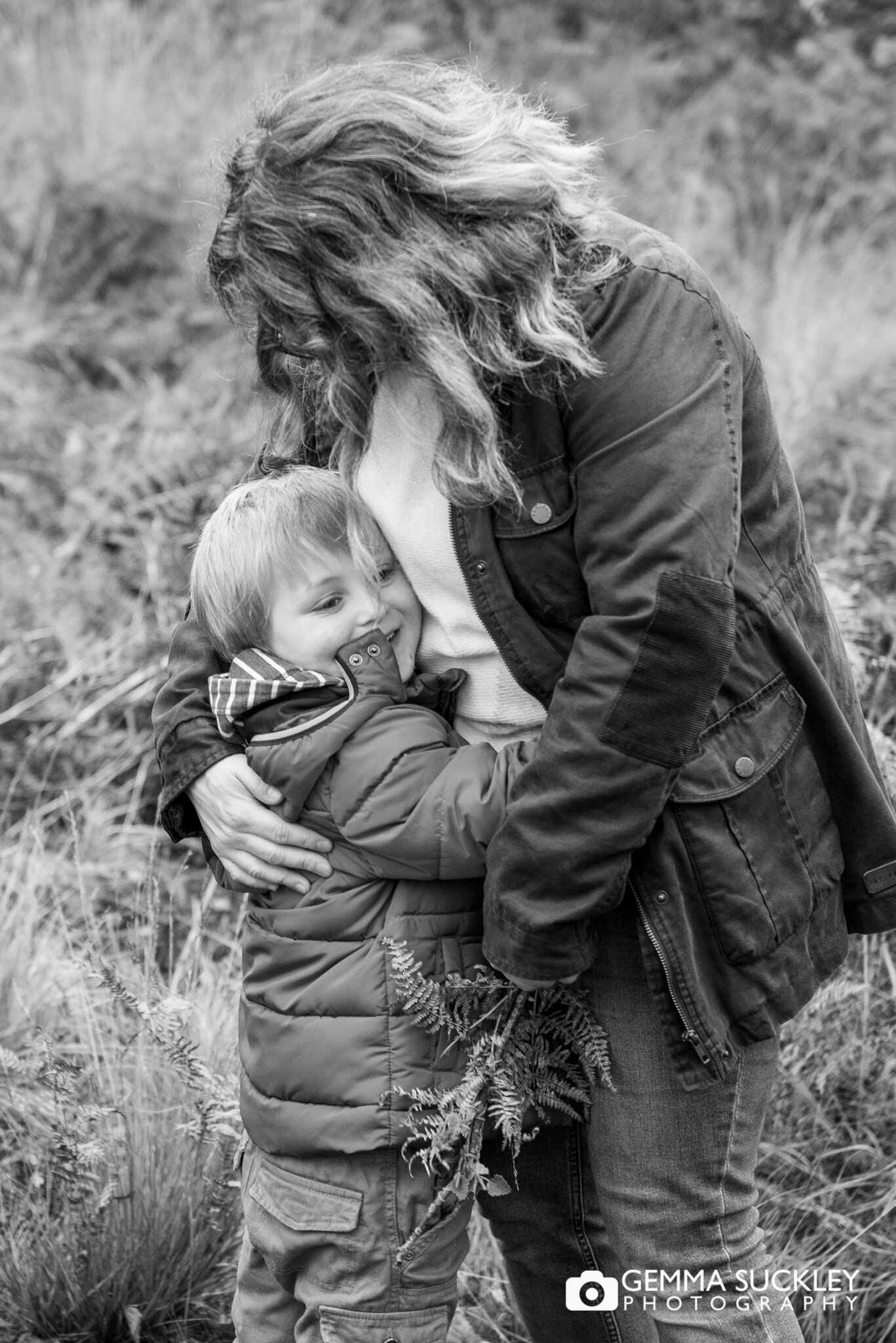 a little boy cuddling his mum during a family photoshoot on farnhill moor