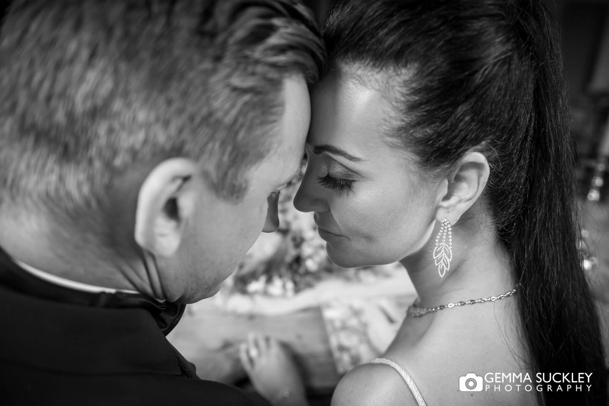 close up photo of a bride and groom forehead to forehead