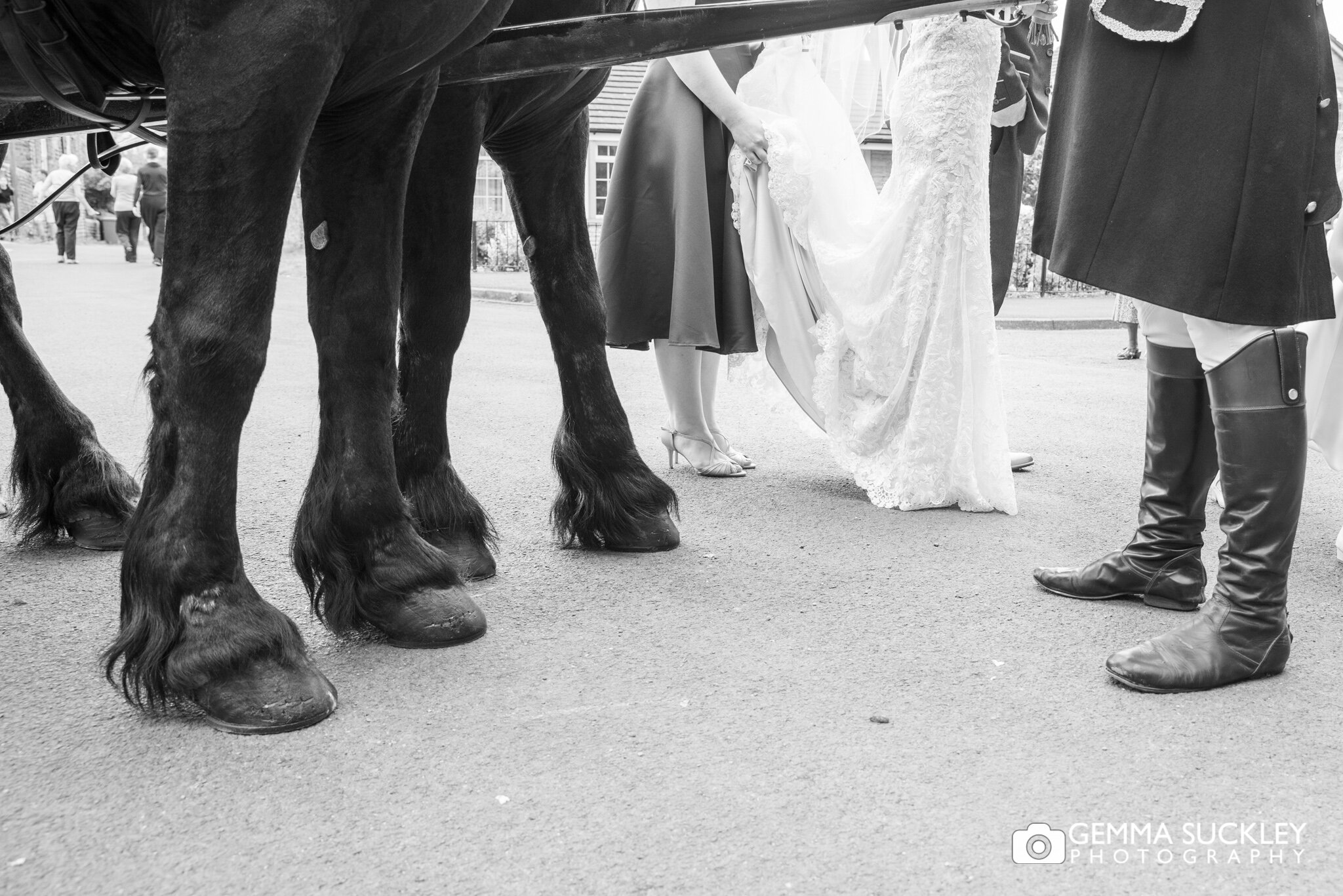 close up photo of horse hoofs next to the brides feets