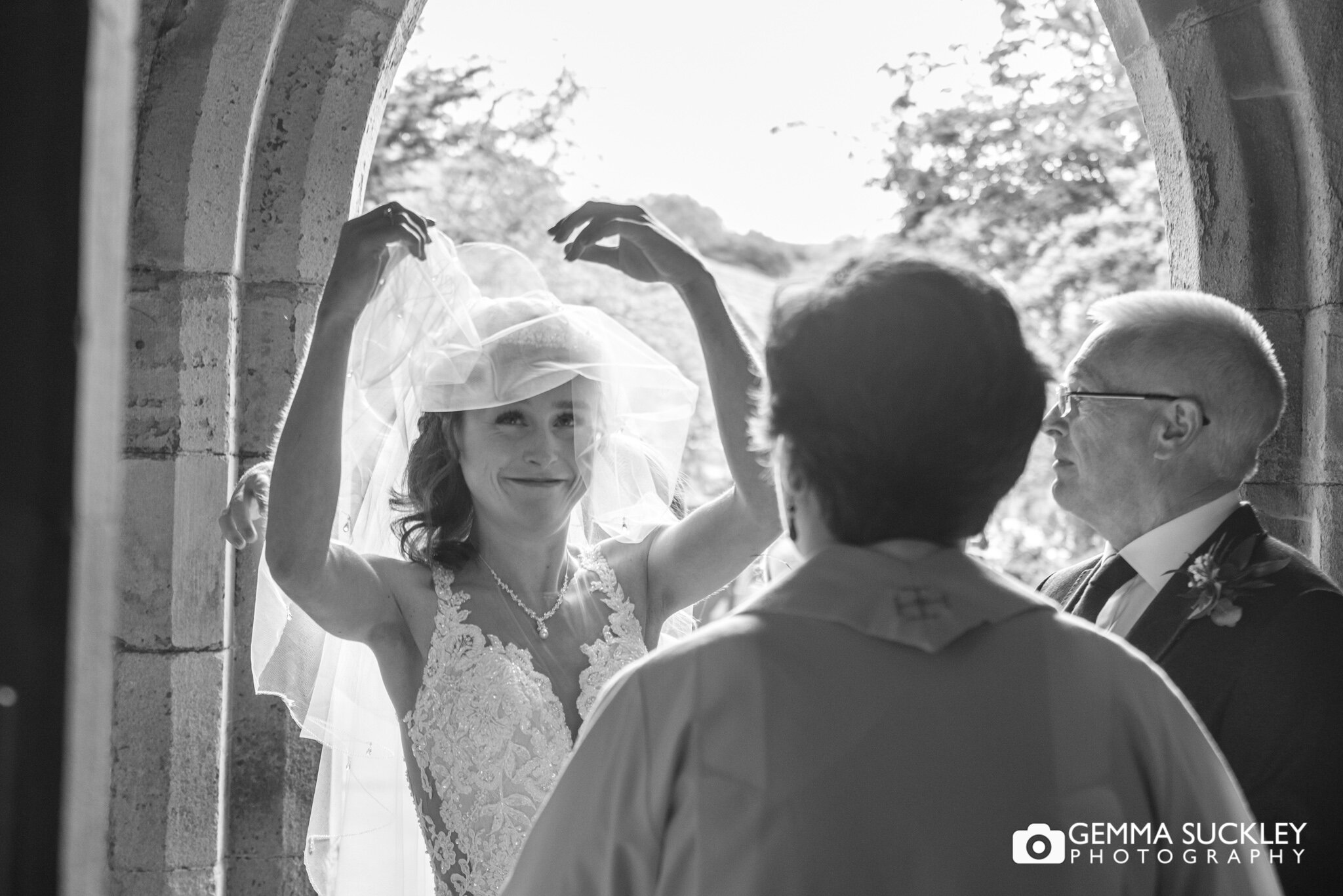 the bride lifting her veil as she enters carleton church 