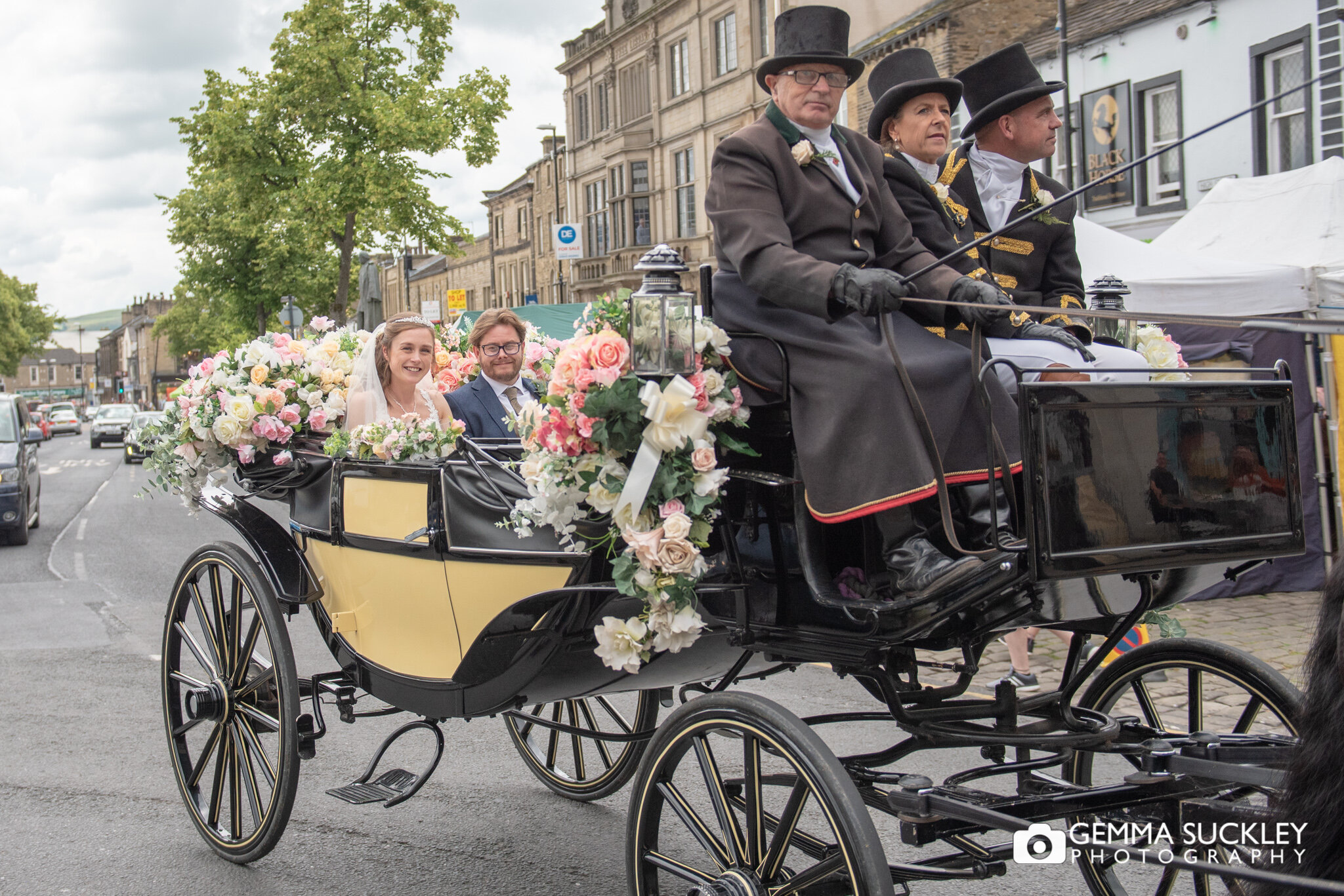 the bride and groom in a carriage pulled my horses on skipton main street 